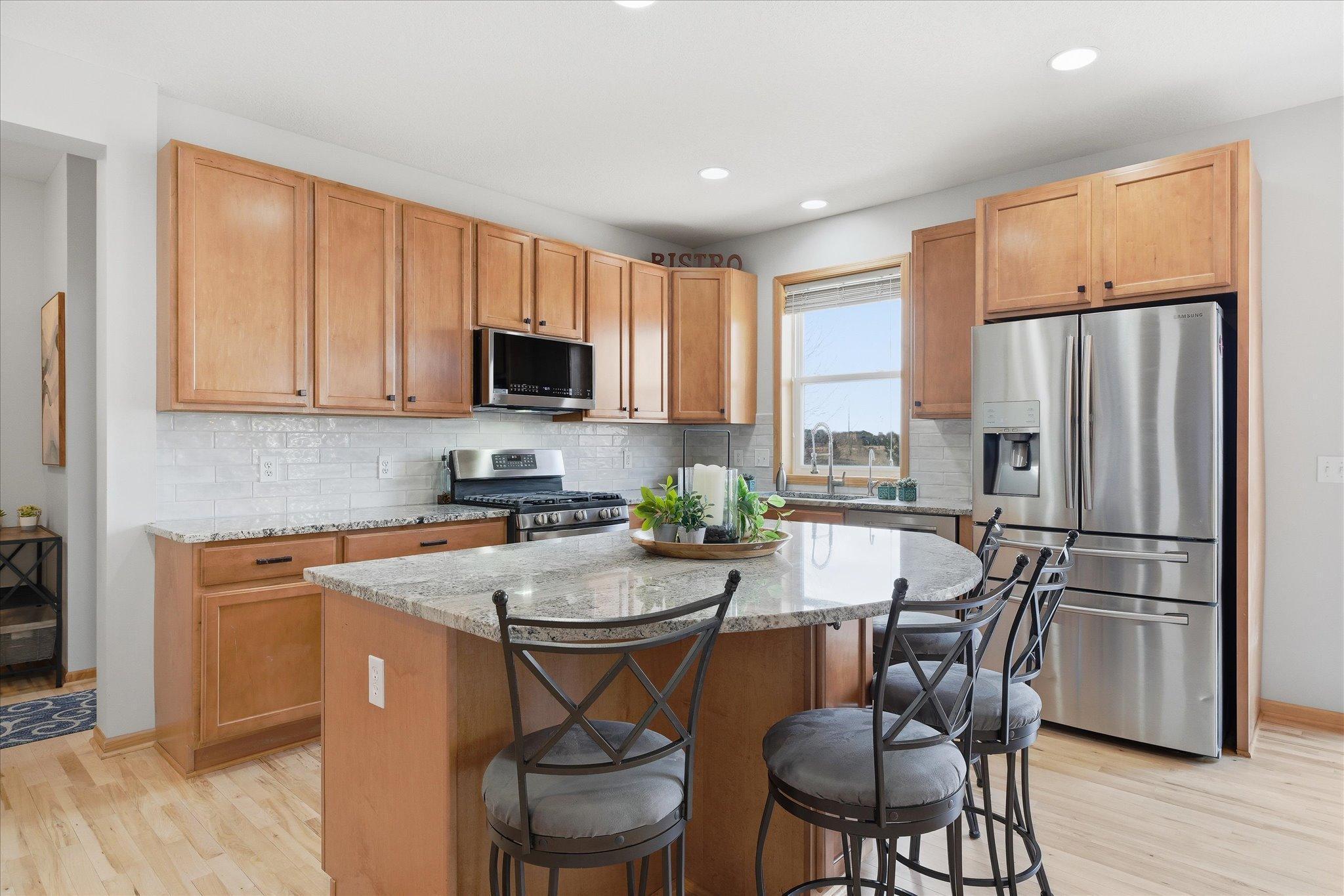 Beautiful updated Kitchen with center island, maple hardwood floors, tile backsplash and granite counter tops