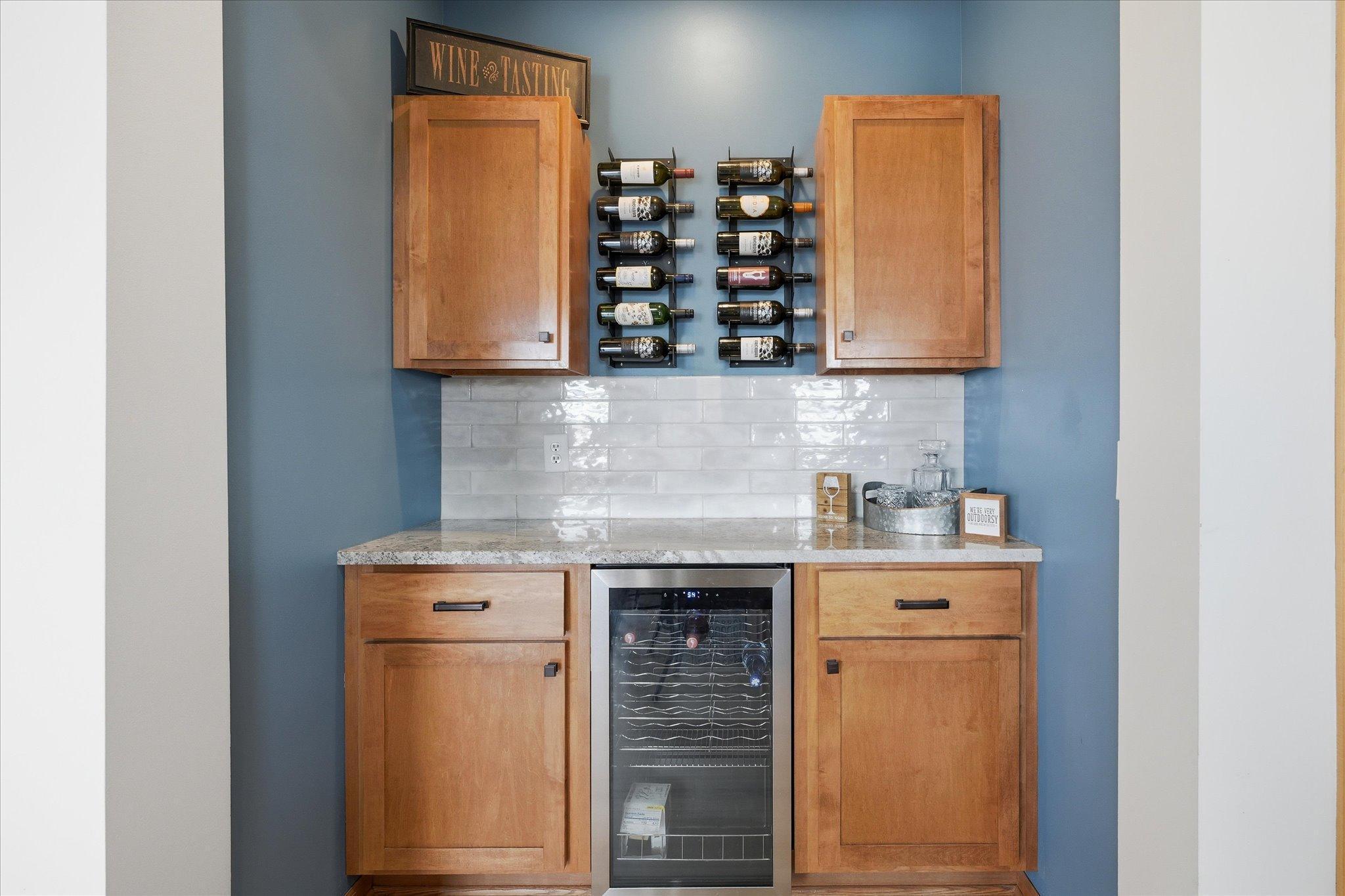 Custom Butler Pantry w/cabinets, granite counter top, tile backsplash and wine refrigerator