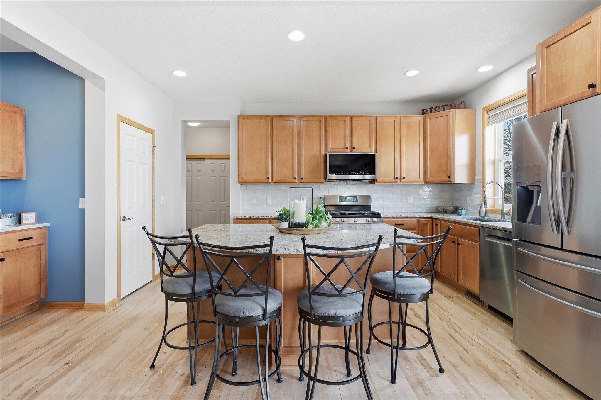 Beautiful updated Kitchen with center island, maple hardwood floors, tile backsplash and granite counter tops