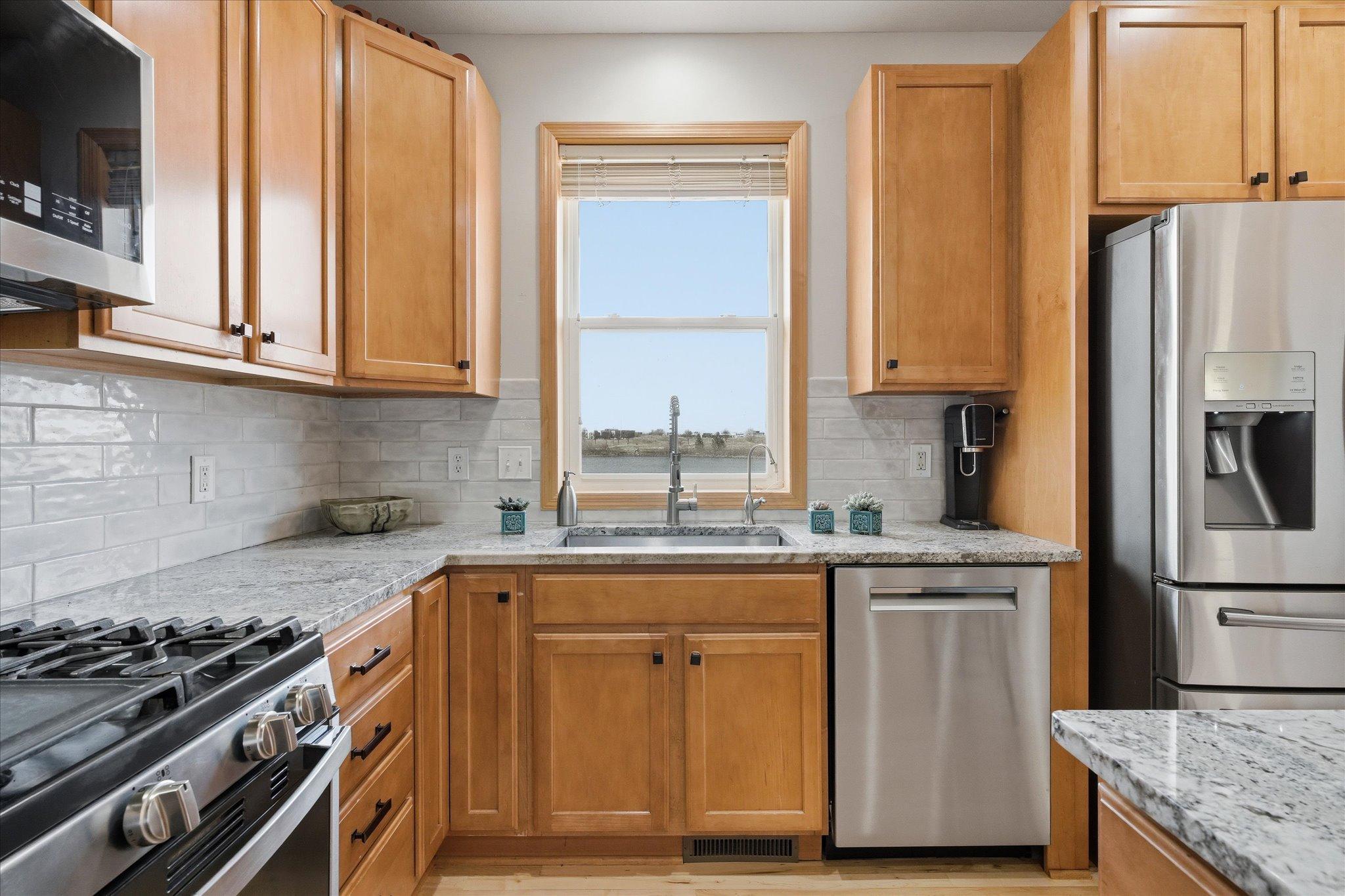 Open Kitchen with maple cabinets, granite counter tops, tile backsplash and ss appliances