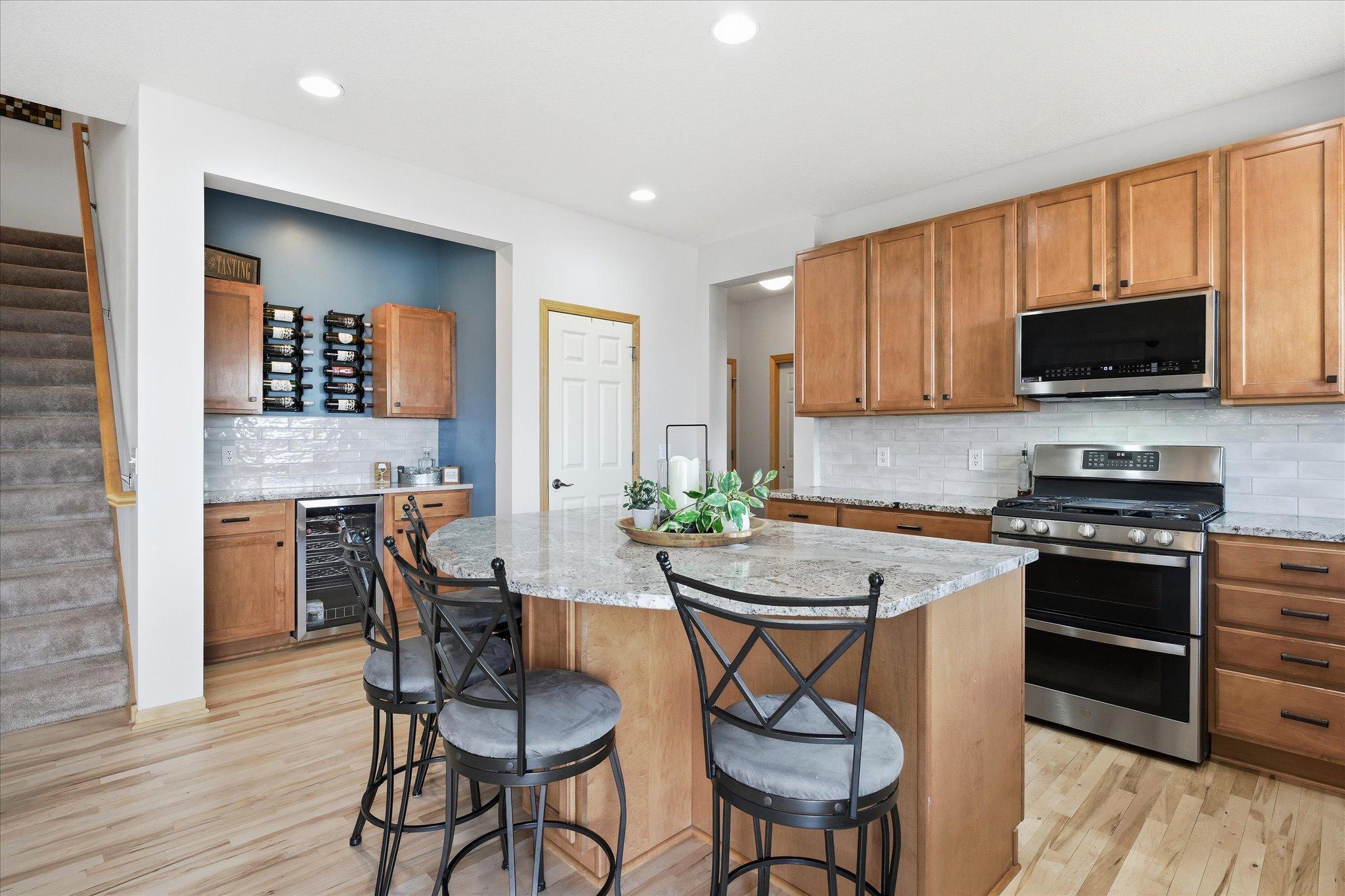 Beautiful updated Kitchen with center island, maple hardwood floors, tile backsplash and granite counter tops