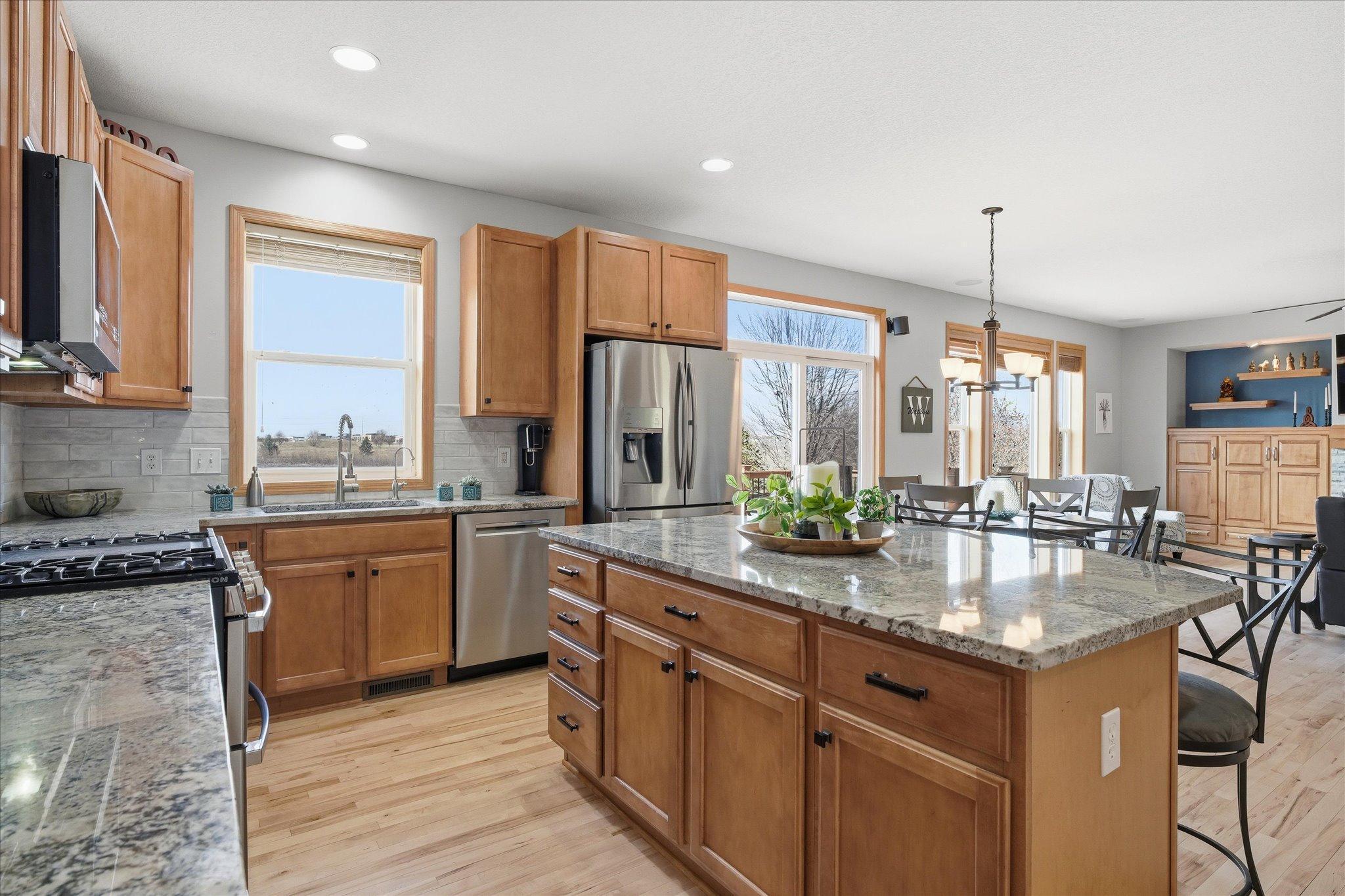 Open Kitchen with hardwood maple floors, granite counter tops, center island and ss appliances