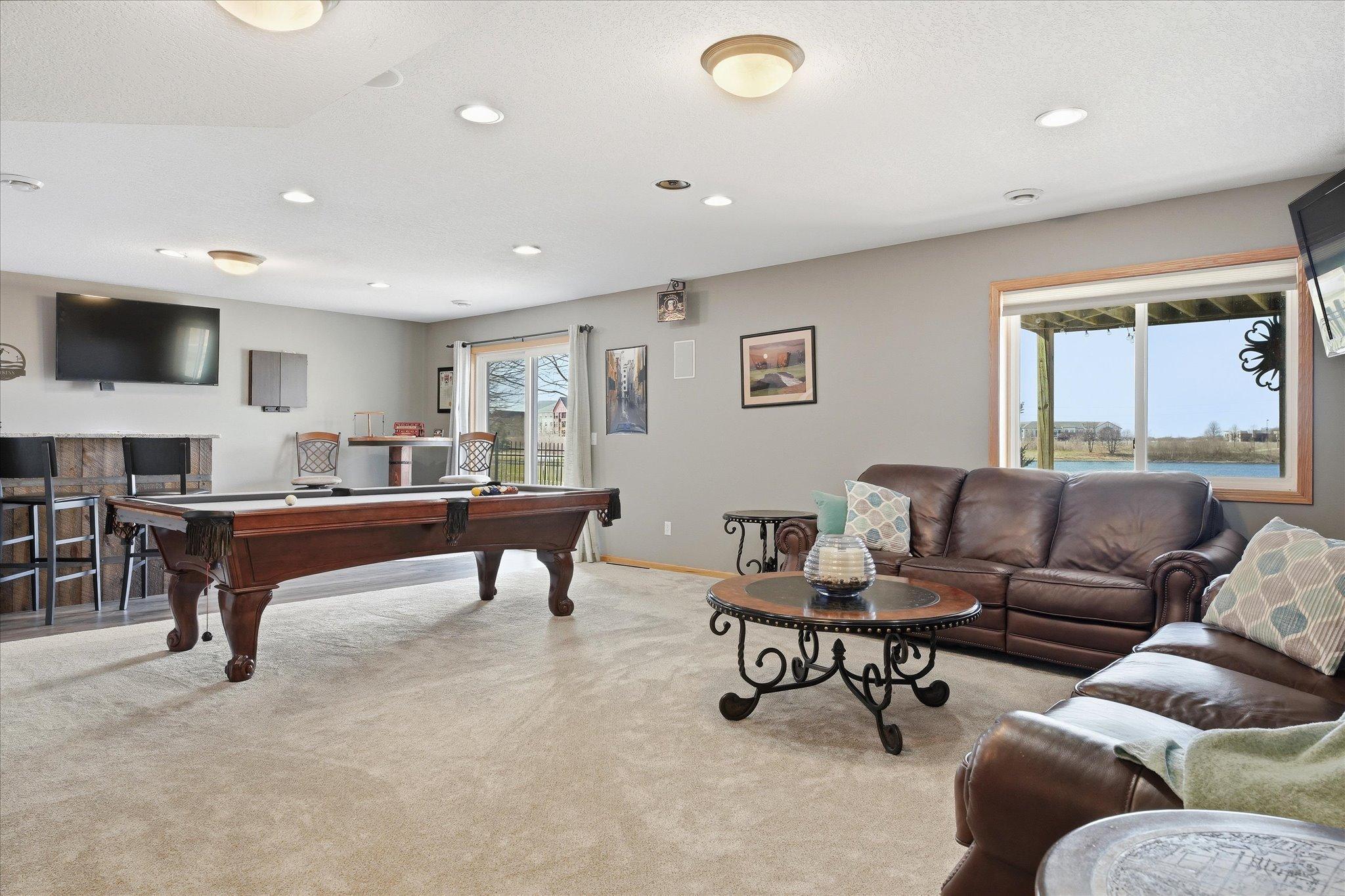 Walkout lower level Amusement Room with recessed lights and wet bar