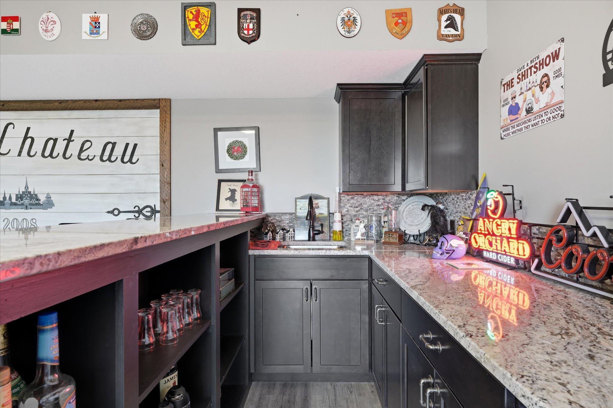 Custom wet bar with granite counter top and dark cabinets