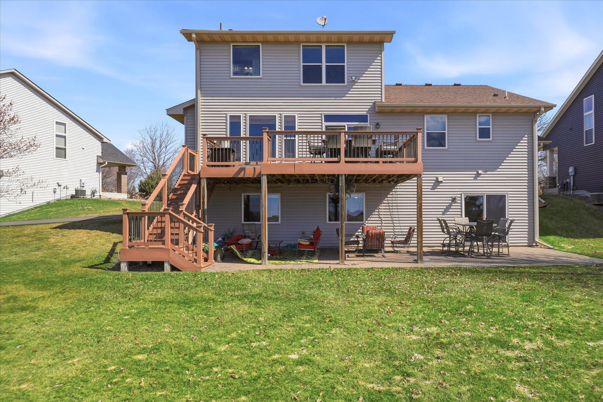 Wonderful pond view exterior with large composite deck and paver patio. Perfect spaces for summer BBQ's and hanging out watching sunsets