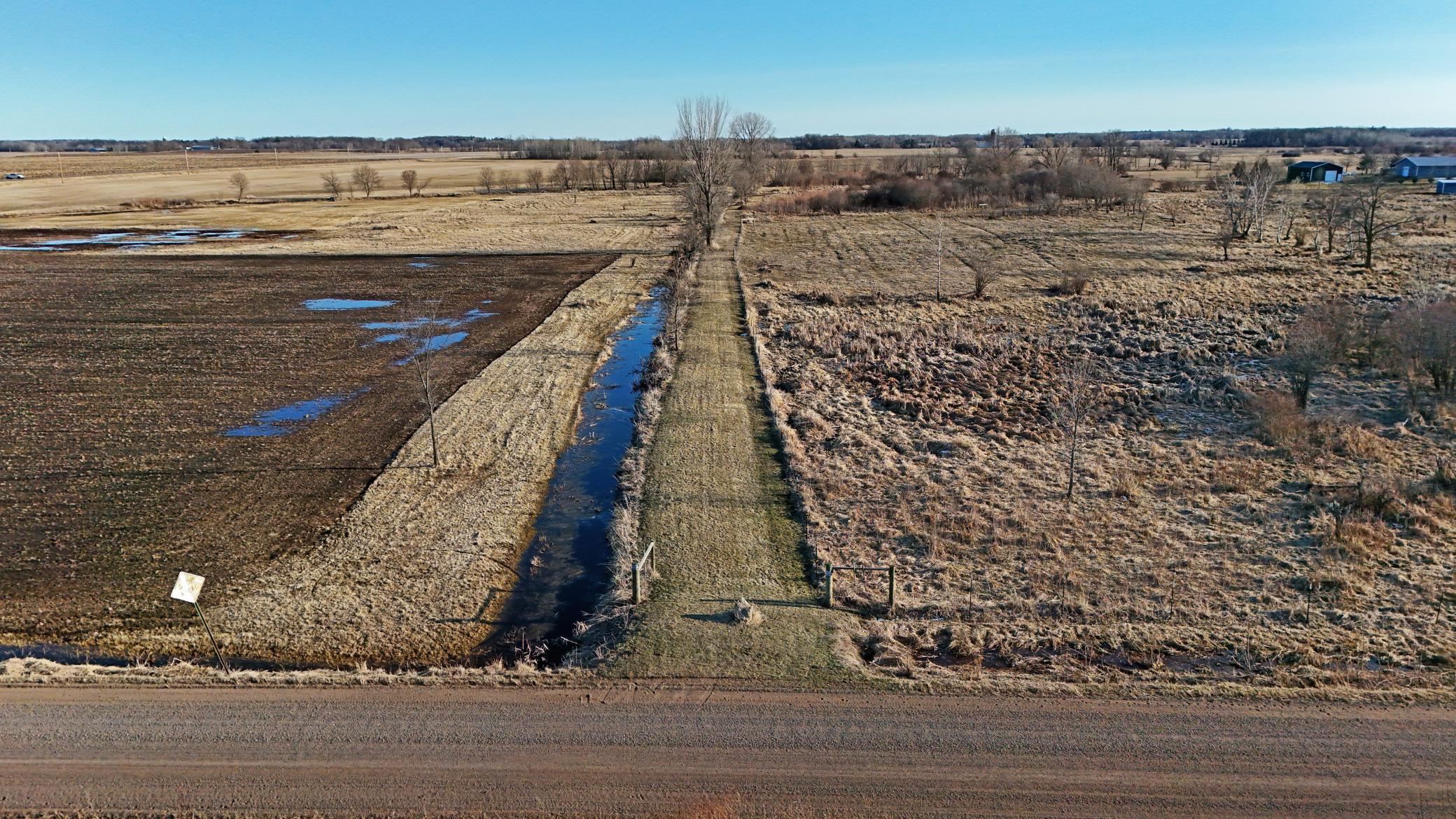 County drainage ditch with 125th Street NE in foreground and driveway access into parcel.