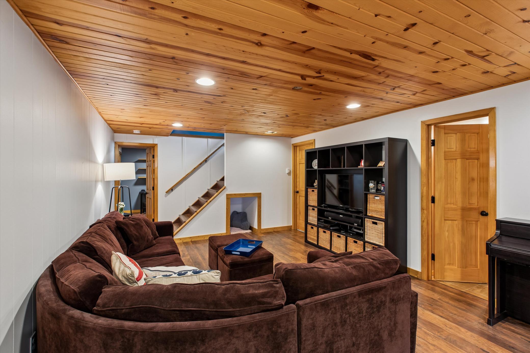 Finished Lower Level Amusement Room with engineered Flooring and Knotty pine ceiling.