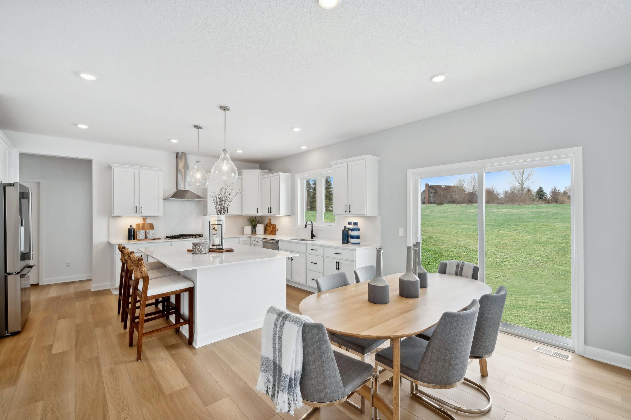 (Photo of a decorated model, actual homes finishes will vary) Soaked in natural sunlight, the homes eat-in dining room has ample space for a dining table located in the heart of the home.