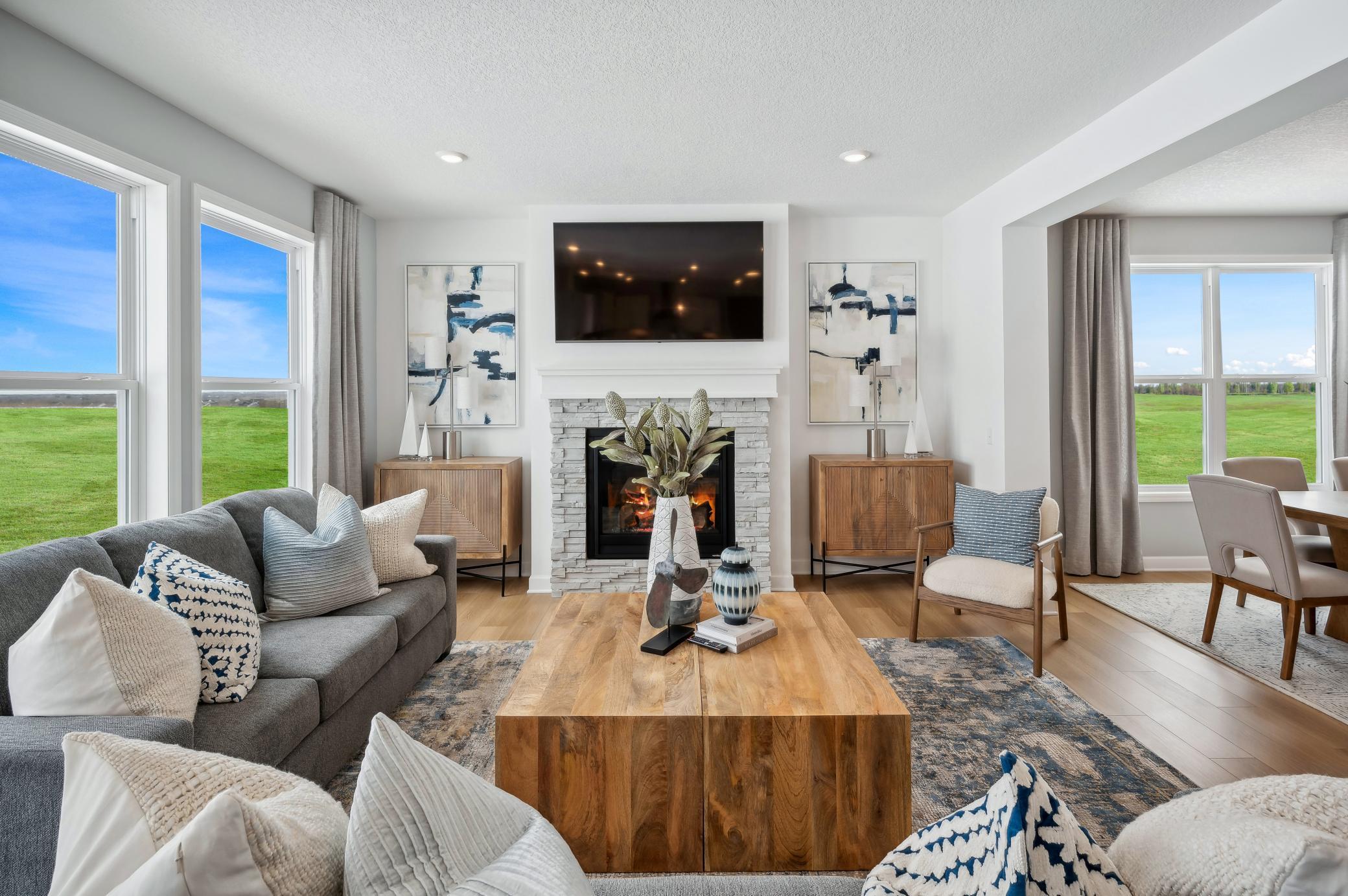 (Photo of a decorated model, actual homes finishes will vary) The spacious family gathering area seamlessly connects to the kitchen area, perfect for entertaining. It also features many large windows providing warm natural light.