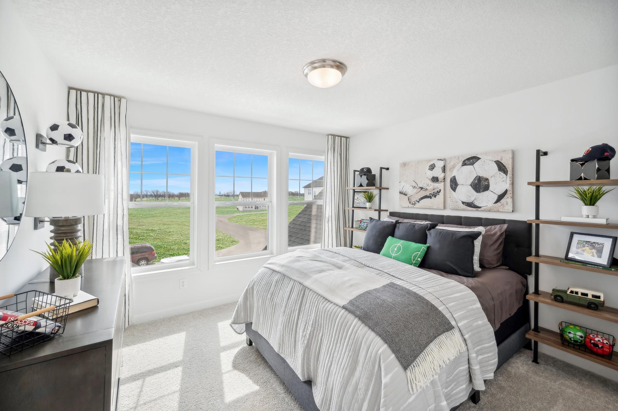 (Photo of a decorated model, actual homes finishes will vary) One of three generously sized upper level secondary bedrooms with spacious closets.