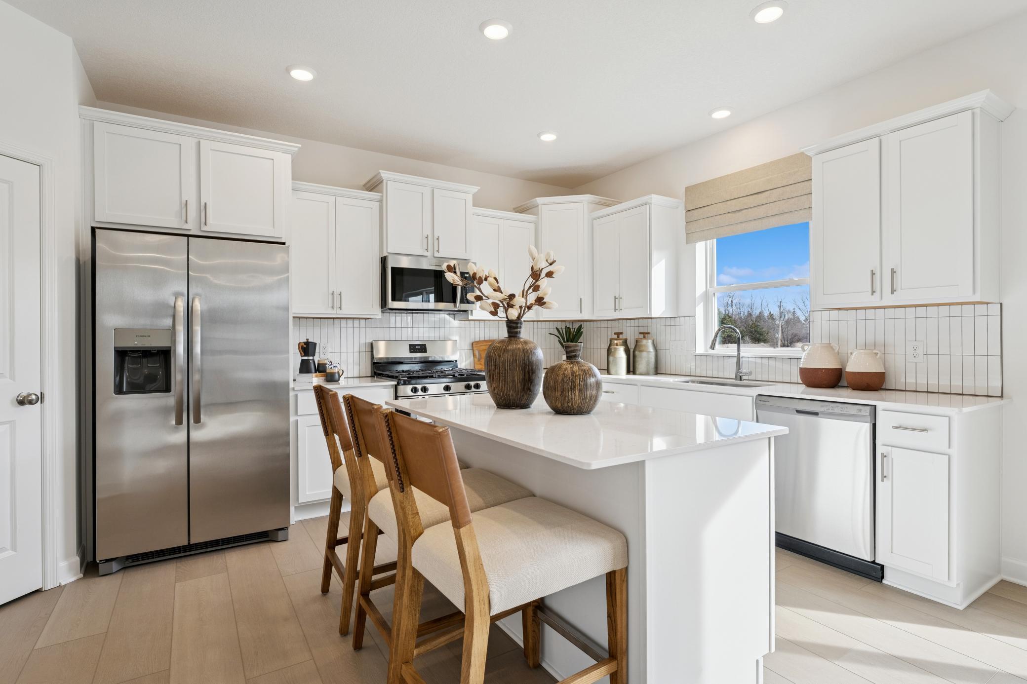 (Photos of model home, finishes will vary) The spacious kitchen features brand-new stainless steel appliances, a center island and ample cabinetry storage.