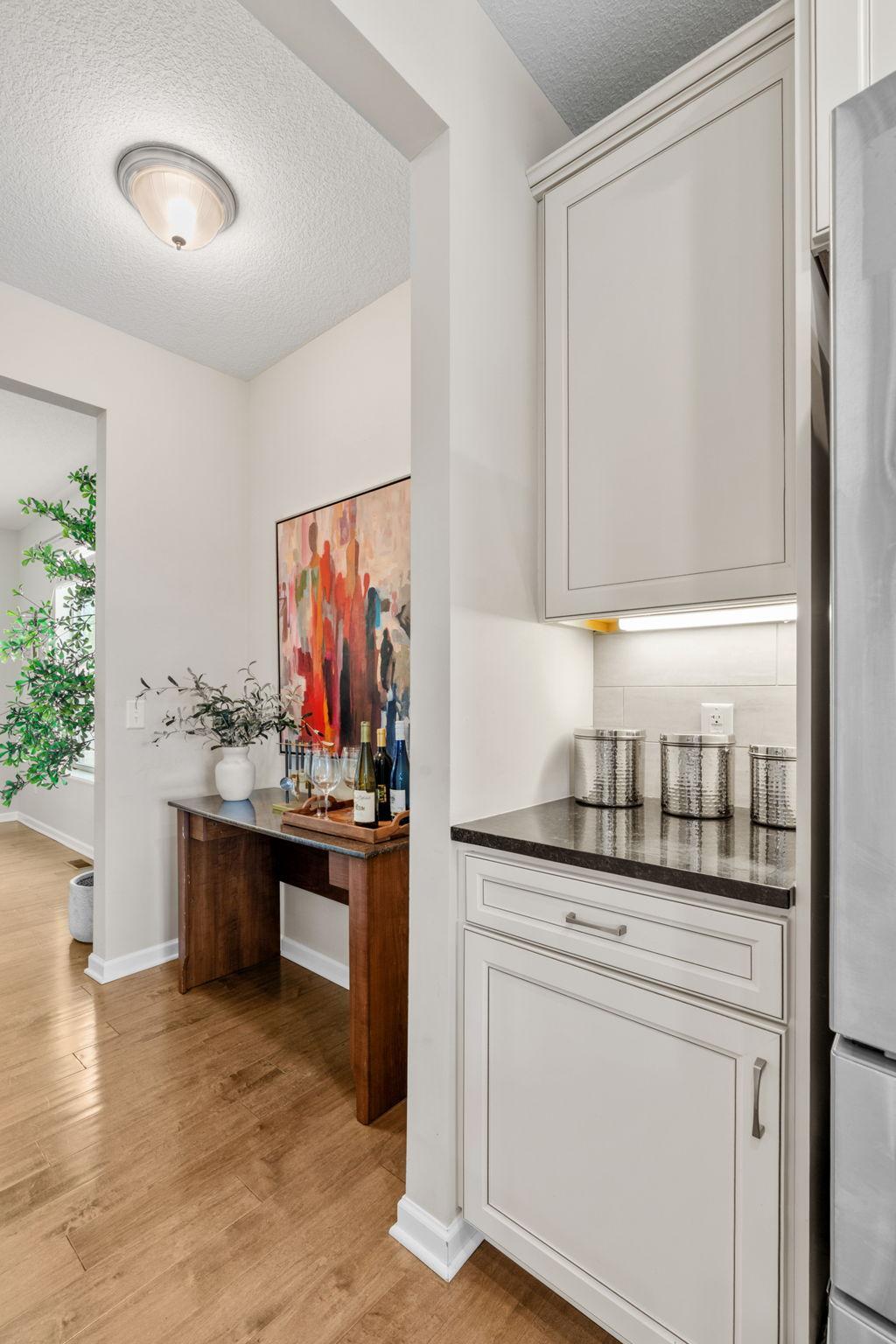 Additional kitchen cabinetry provides a handy storage area tucked right next to the refrigerator, ideal for everyday organization.