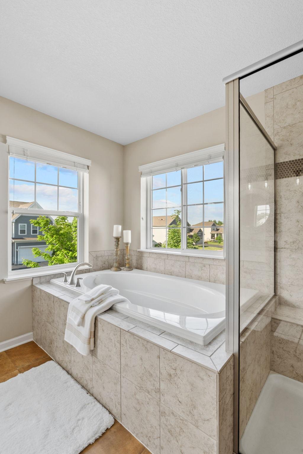 Unwind at the end of the day in the large soaking tub, framed by bright windows overlooking the quiet neighborhood below.