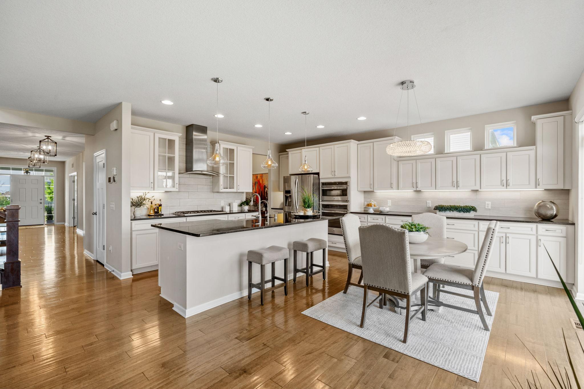 An all-encompassing view of the main floor hub reveals a spacious eat-in dining area adjacent to sliding glass doors that lead out to the deck.