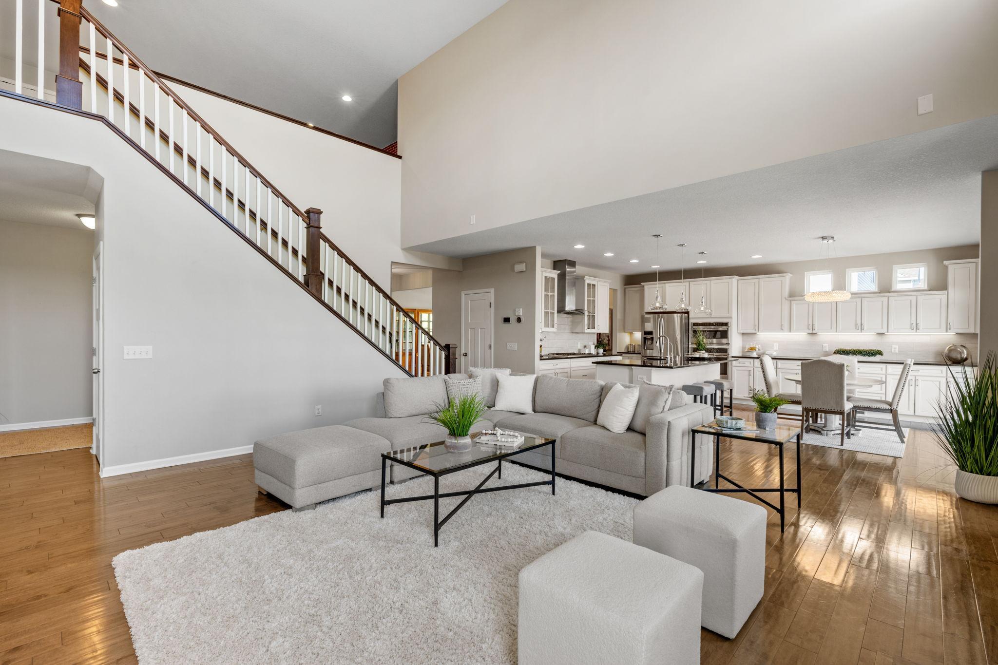 Another angle of the great room showcases the open sightlines to the kitchen, beautiful hardwood flooring, and impressive architectural scale.