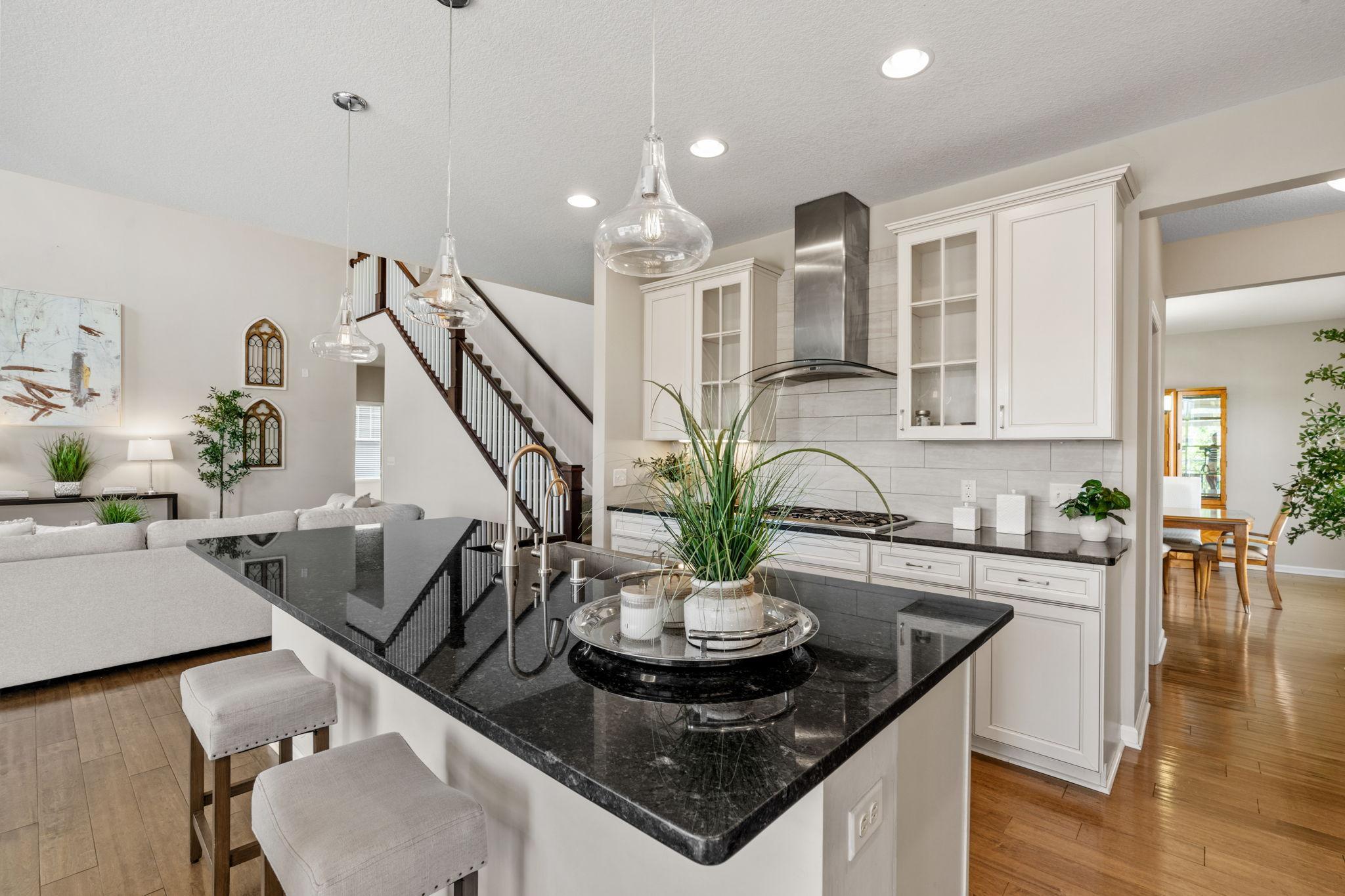 The expansive kitchen island offers plenty of room for casual morning seating while keeping sightlines open to the adjoining living space.
