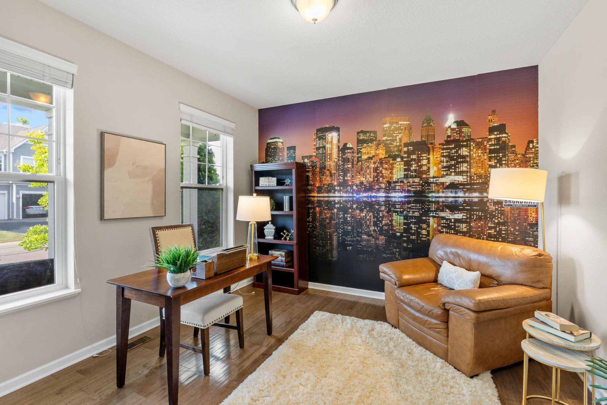 Work from home in style. This bright office features large windows for great natural light, warm wood tones, and a striking city skyline accent mural.