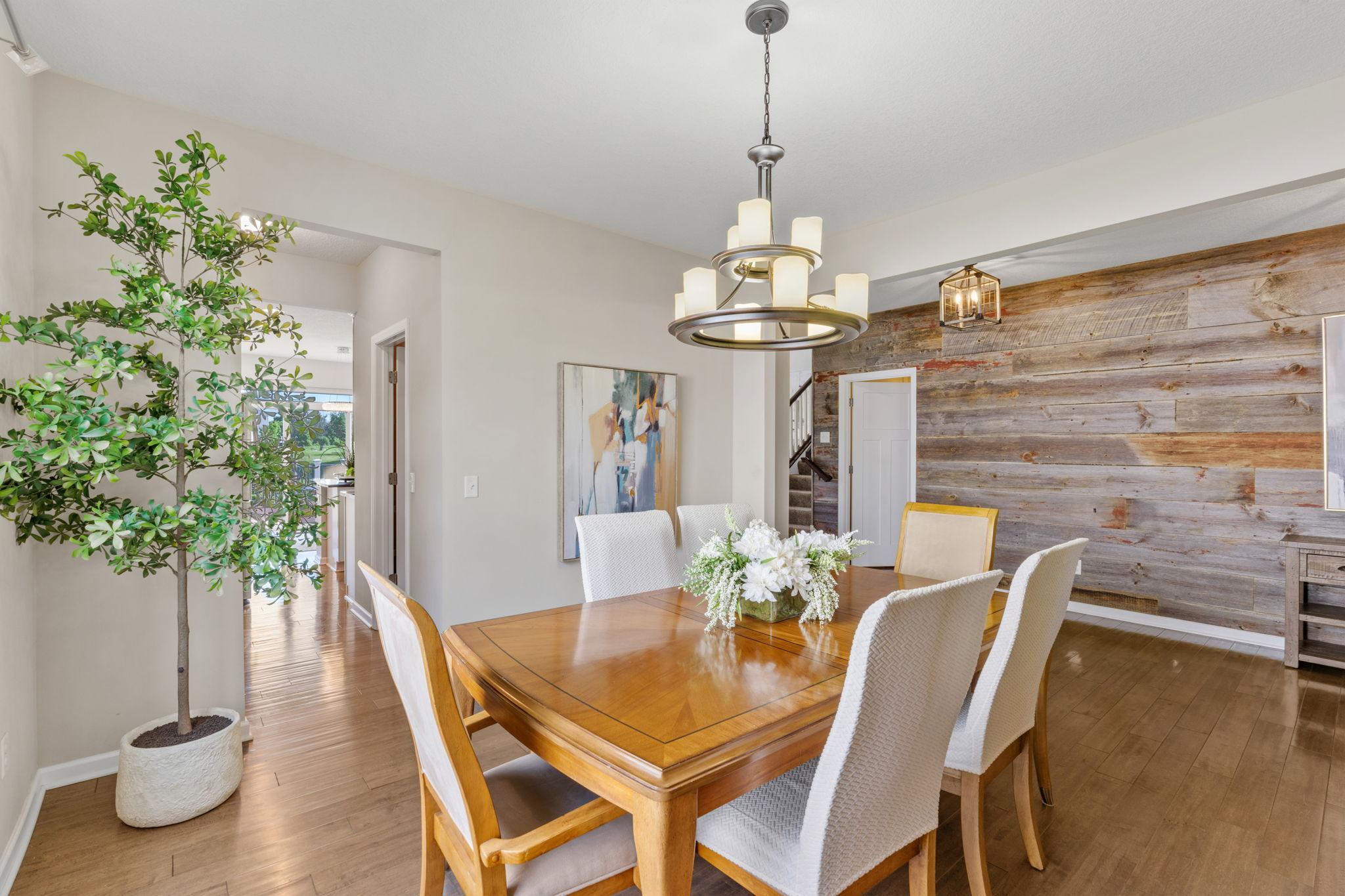 Another look at the dining area showcases the seamless visual transition into the front foyer with its rustic, custom wood accent wall.