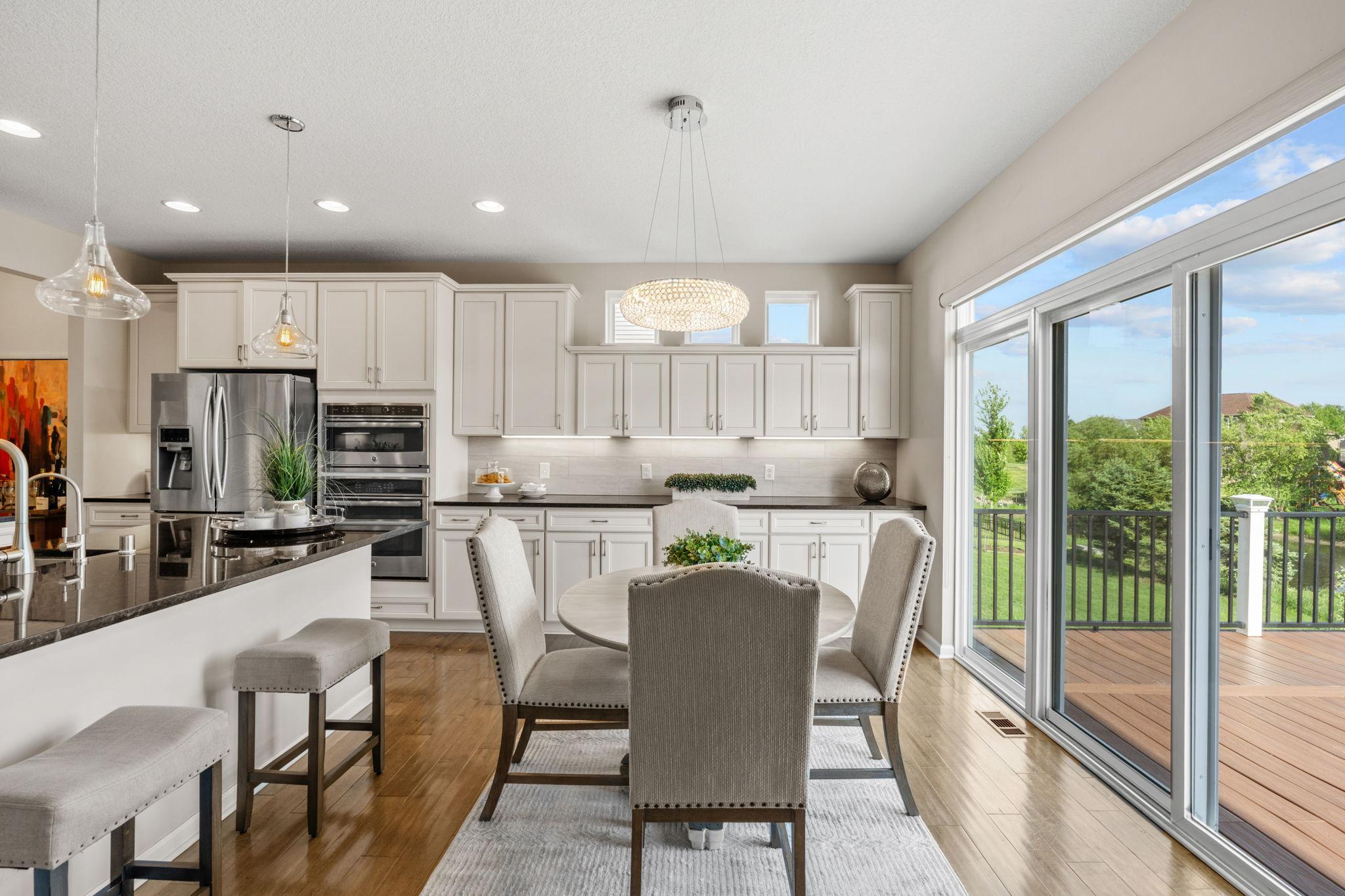 The bright, everyday dining space is positioned perfectly along oversized sliding glass doors, looking out directly to the deck.