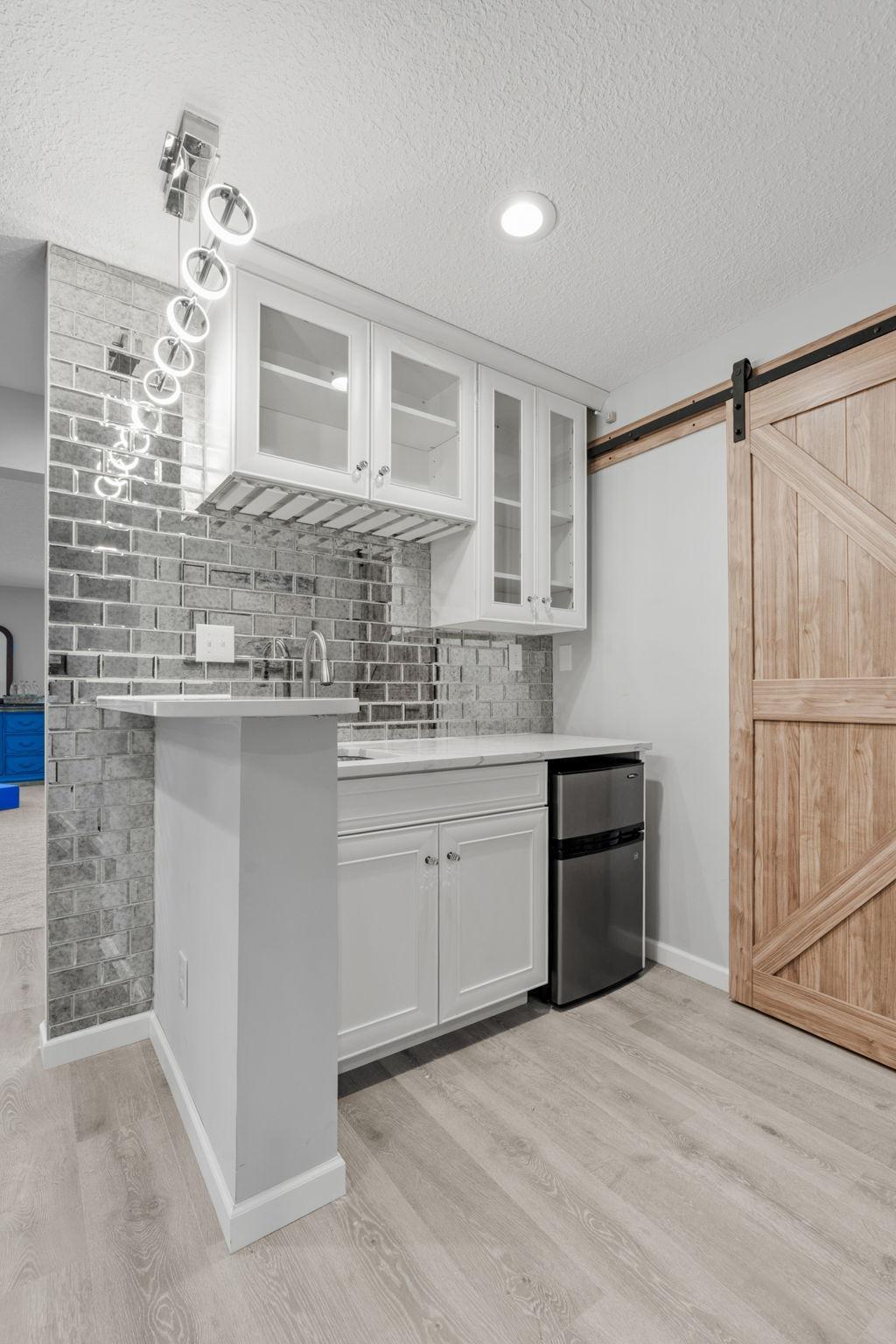 A beautiful, rustic sliding wood barn door adds architectural character while smartly concealing lower-level mechanicals or storage space.
