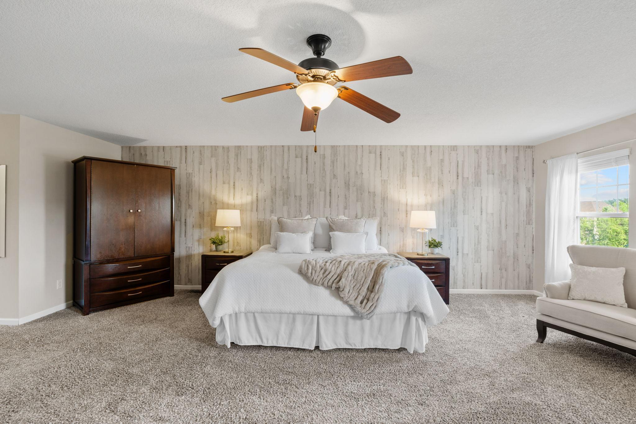 The vast layout of the primary suite easily accommodates large bedroom furniture sets while leaving plenty of room for an intimate seating arrangement.