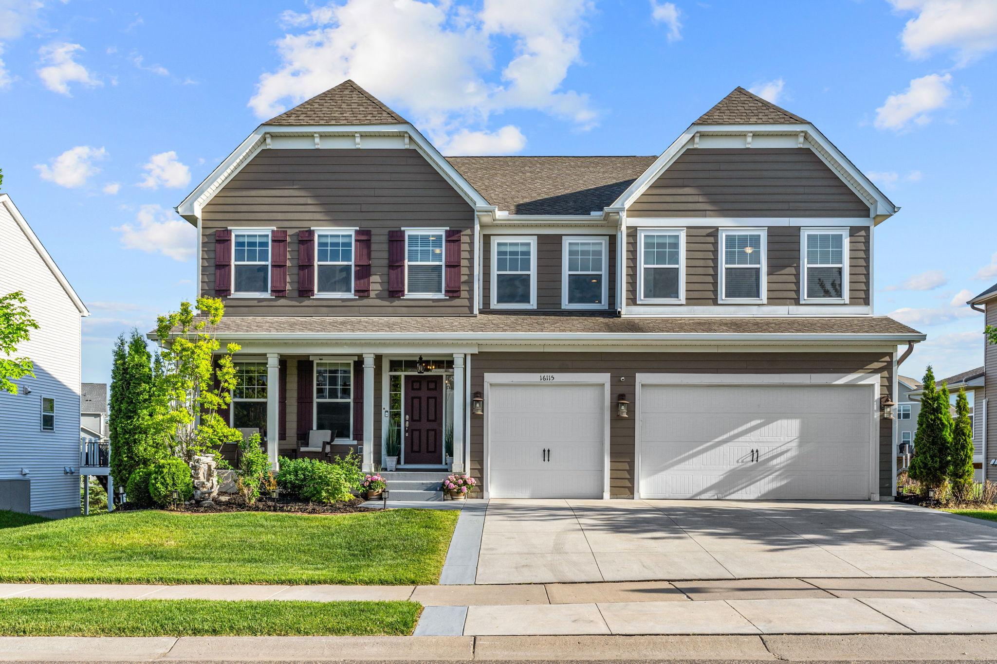 A closer look at the elegant exterior reveals gorgeous contrast shutters, sophisticated architectural gables, and a cozy covered front porch perfect for morning coffee.