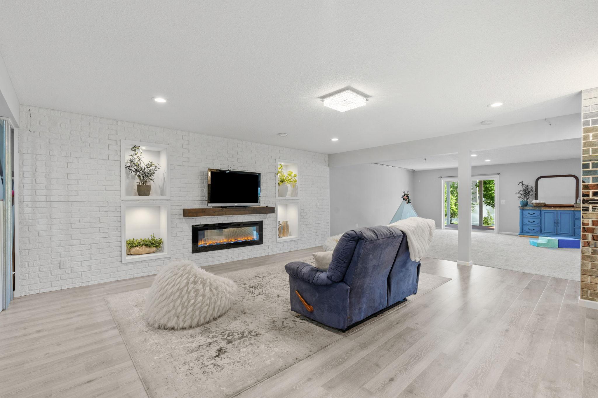 An open-concept view demonstrates the smooth, expansive flow between the cozy fireplace media zone and the sprawling recreation areas beyond.