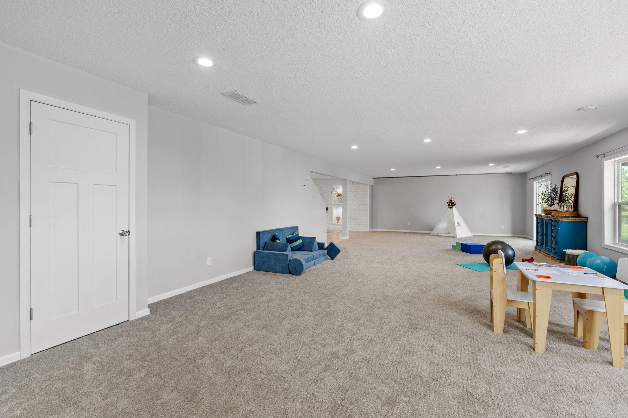An alternate view looking back across the immense carpeted layout, highlighting pristine neutral walls and unlimited customization possibilities.