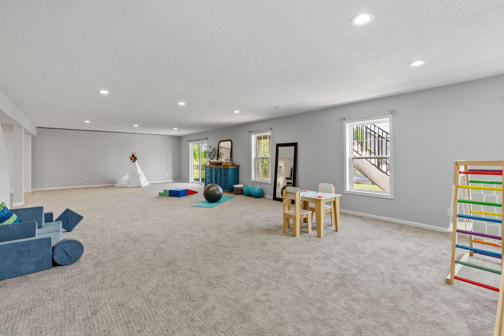 An alternate angle of the massive carpeted walk-out basement highlights the endless space available for fitness gear, play zones, and custom entertainment setups.