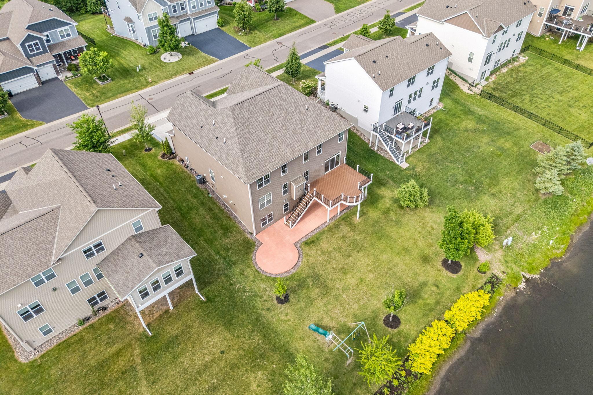 See the perfect harmony of the multi-level deck, custom patio, wide lawn, and direct proximity to the water.