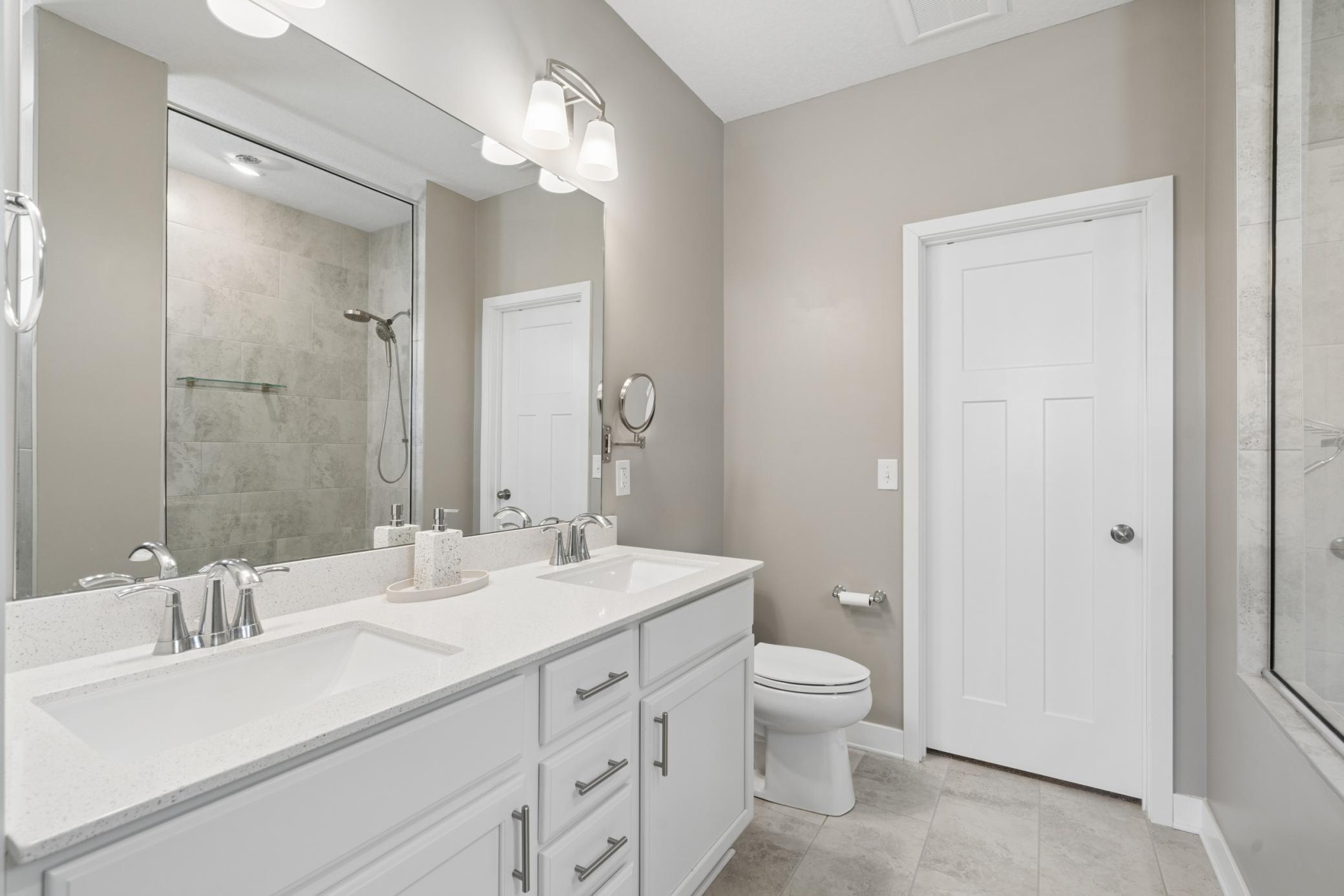 Spacious and bright with double sinks, modern fixtures, and a large mirror — designed for convenience and style.