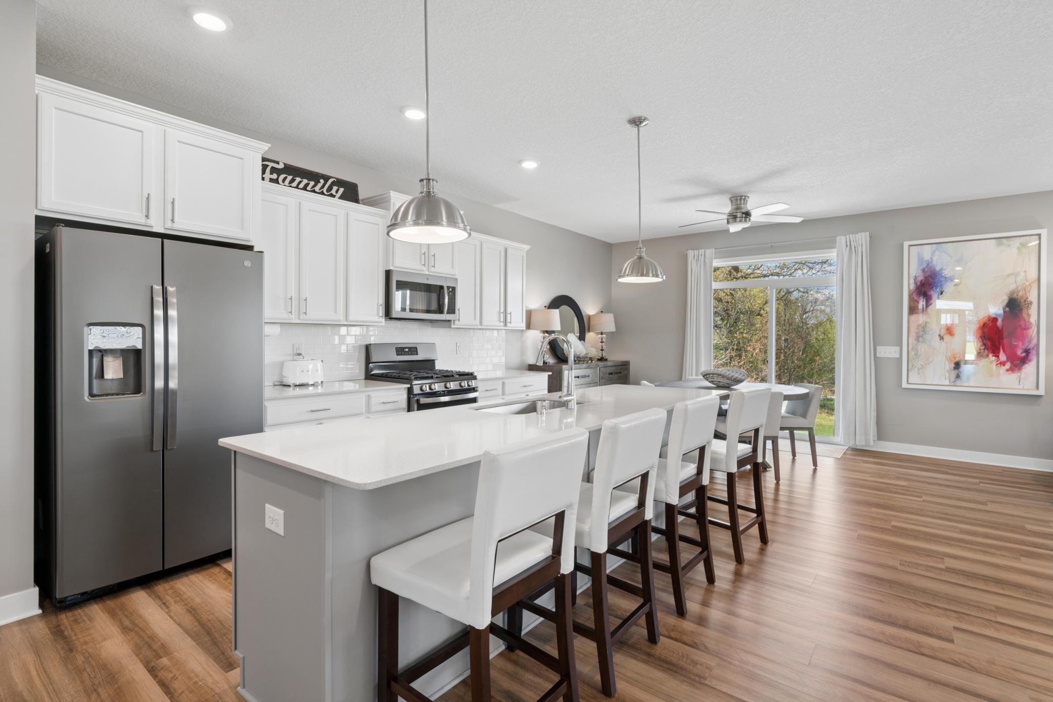 White cabinetry, stainless appliances, and a large island with seating — perfect for casual meals and entertaining.