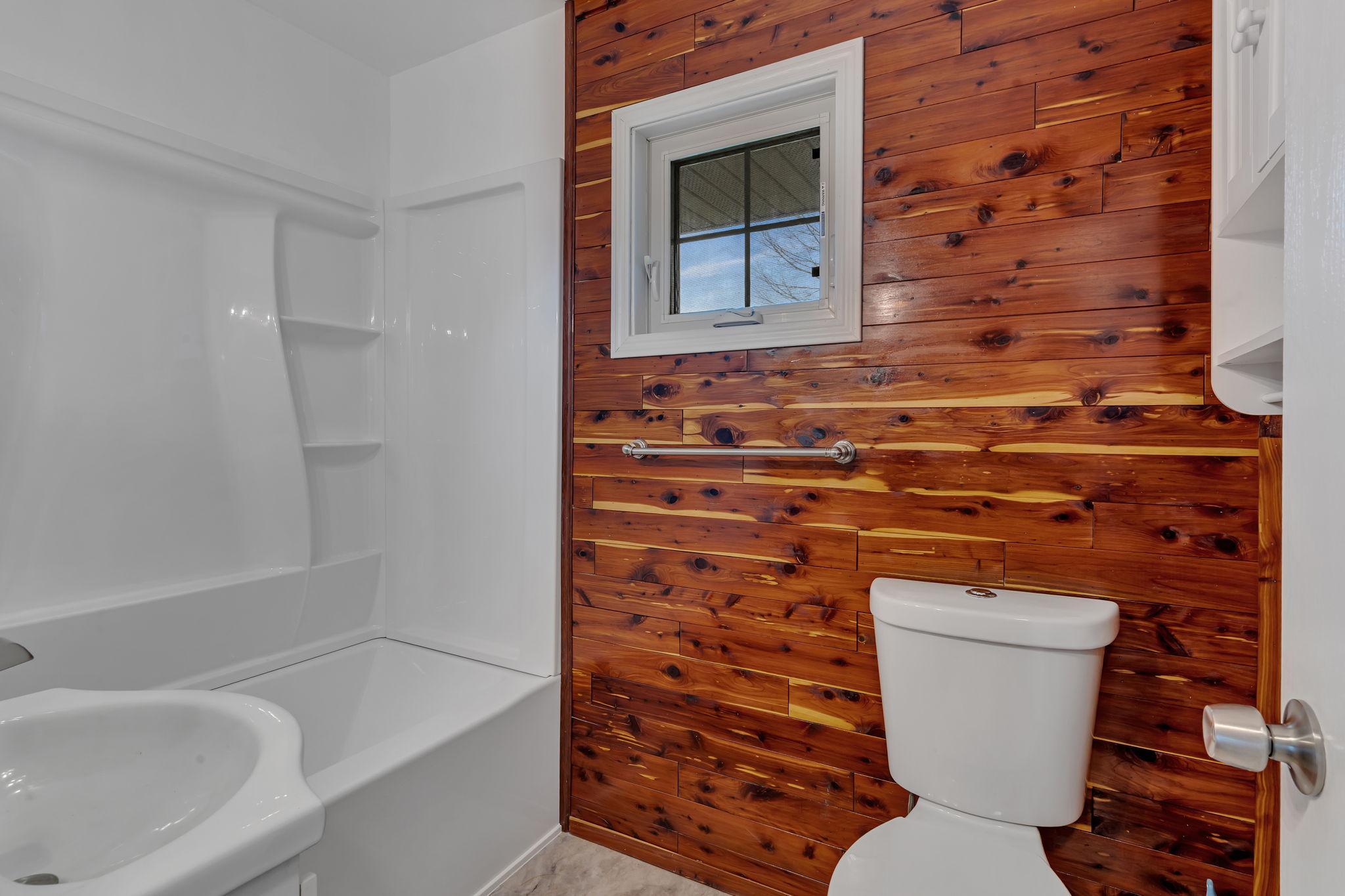This bathroom has a brand new tub and shower surround, toilet and sink.