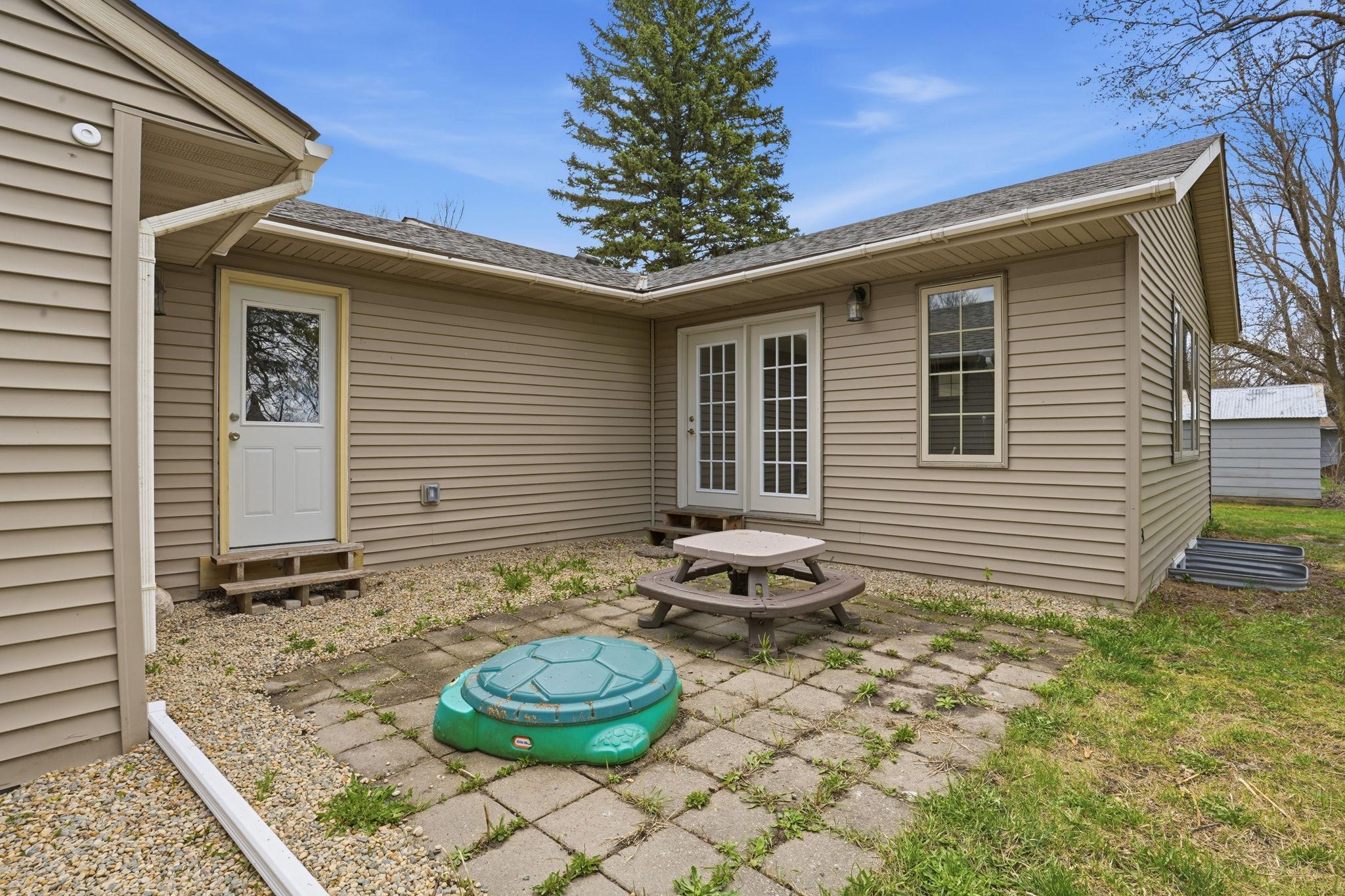The patio is tucked in between the house and garage. And also has access to the mudroom.