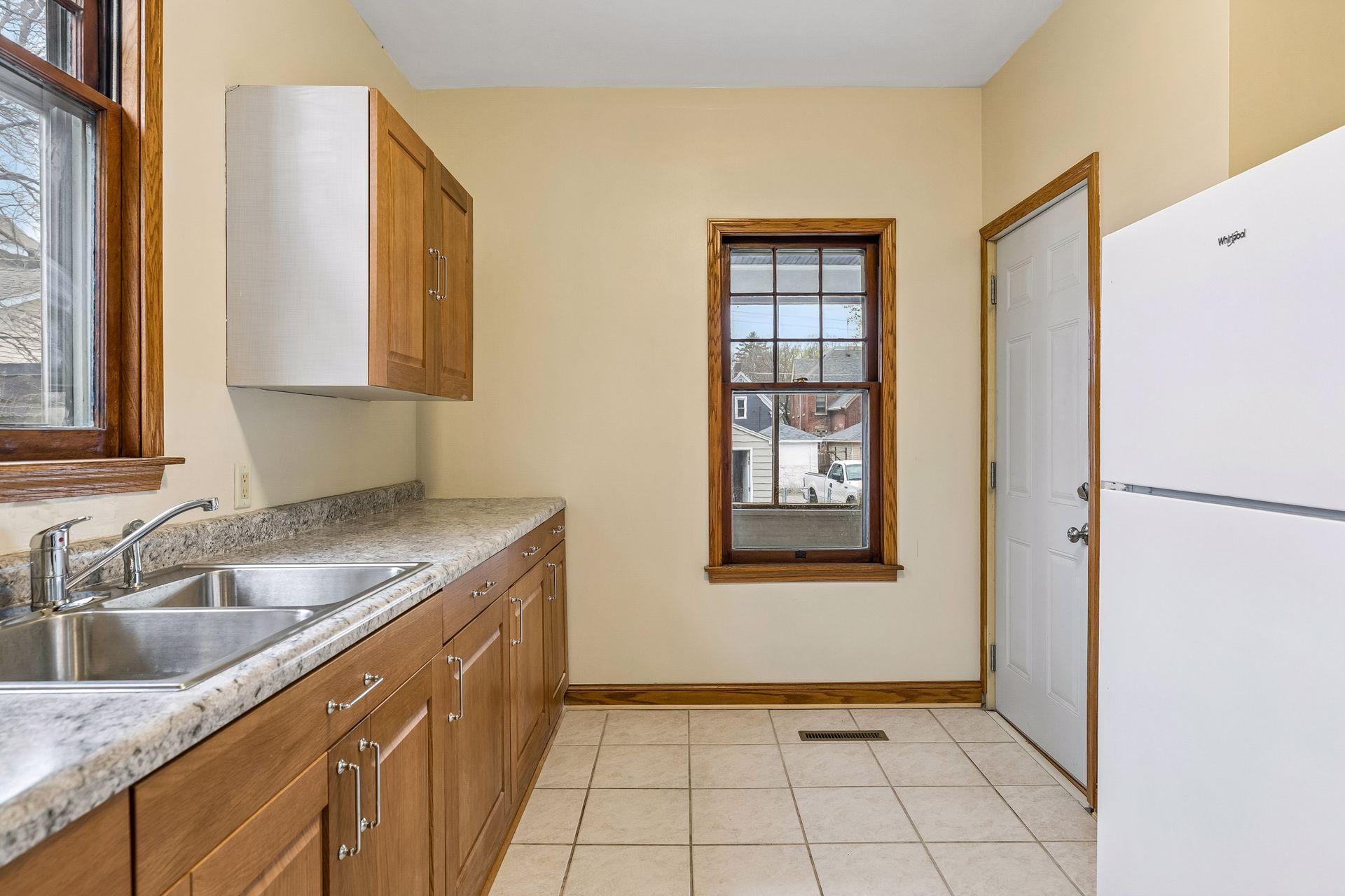 Natural light fills the kitchen, with convenient access to the back porch and upper-level unit.