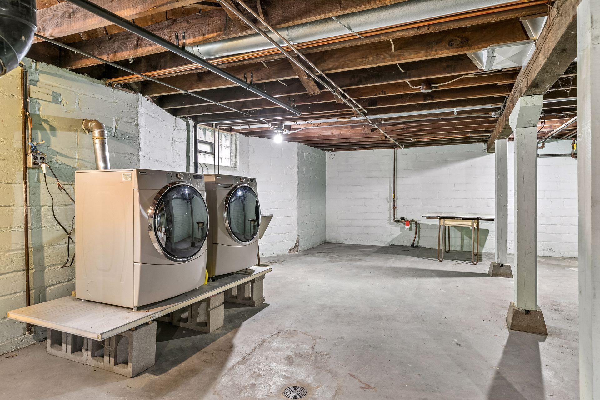 The lower level offers ample storage space and includes a shared laundry area, ready for future customization.