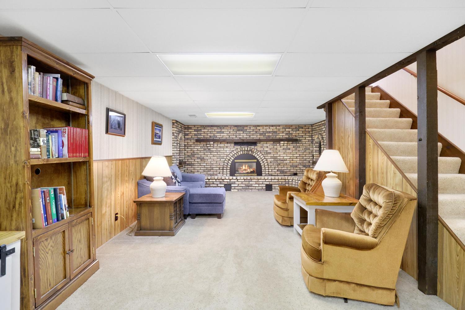 Expansive lower-level family room with a second fireplace perfect for movie nights, game days, or creating your ideal hangout space.