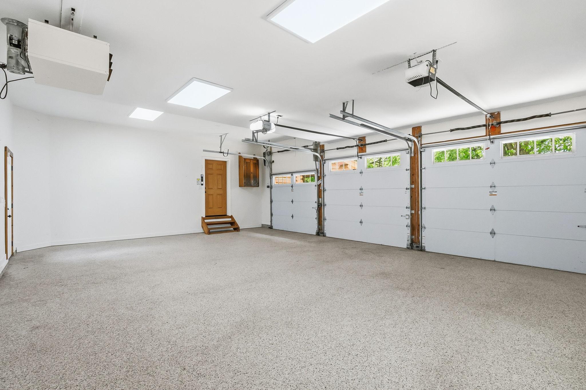 Fresh epoxy flooring and a heated interior create a clean, polished extension of the home, while the convenient service door adds everyday functionality for hobbies, storage, and seamless outdoor access.