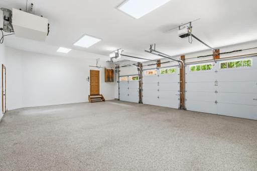 Fresh epoxy flooring and a heated interior create a clean, polished extension of the home, while the convenient service door adds everyday functionality for hobbies, storage, and seamless outdoor access.