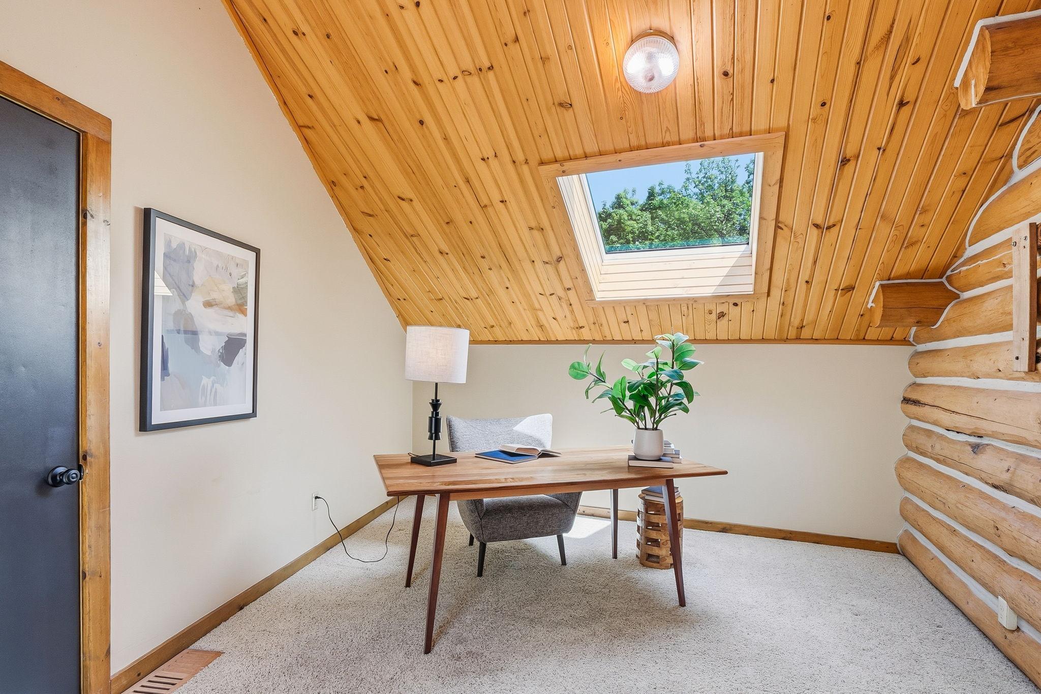 A bright and versatile upper-level space highlighted by skylights and vaulted ceilings, offering the perfect flex room for a home office, lounge, or additional living area.