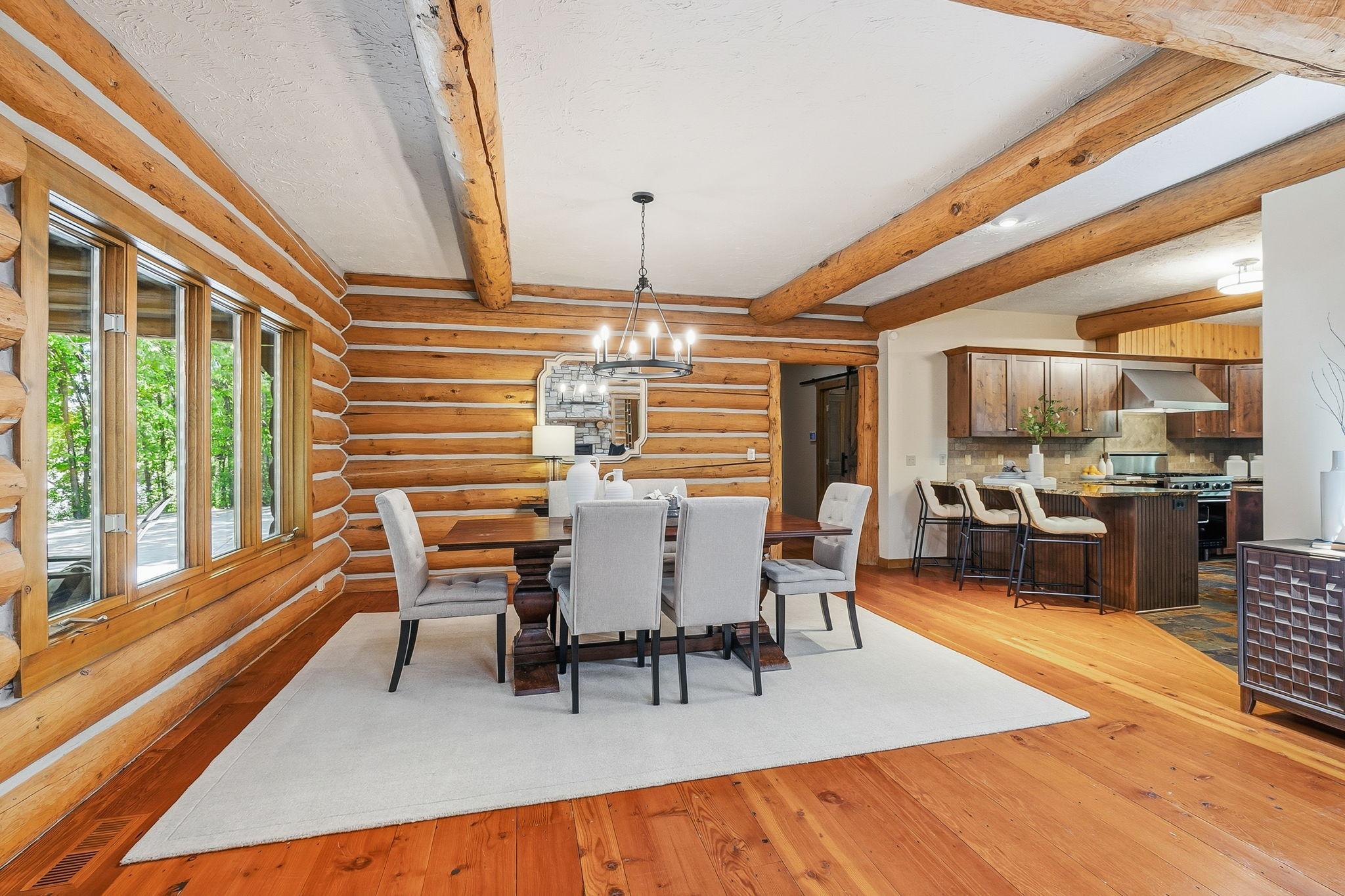 A versatile formal dining space framed by stunning log accents and warm wood textures—offering an inviting setting for memorable gatherings, celebrations, or an elevated everyday dining experience.