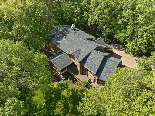 A stunning log home set on a picturesque, tree-lined lot, featuring a welcoming front porch and expansive driveway; offering a perfect blend of privacy, presence, and timeless curb appeal.