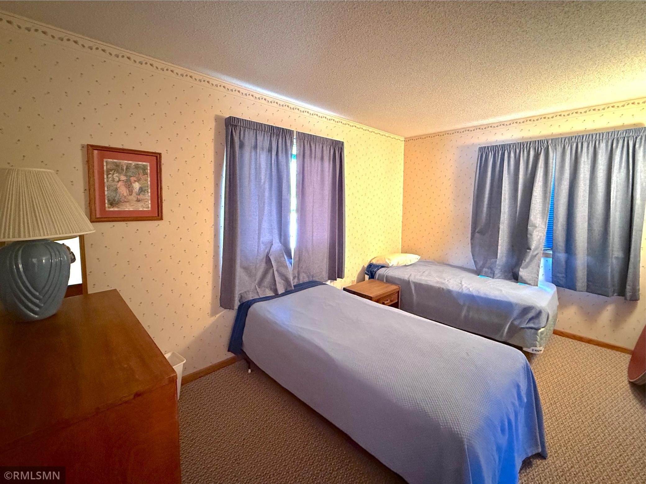 This main level bedroom offers a comfortable and versatile space, perfect for guests or everyday living with a cozy atmosphere.