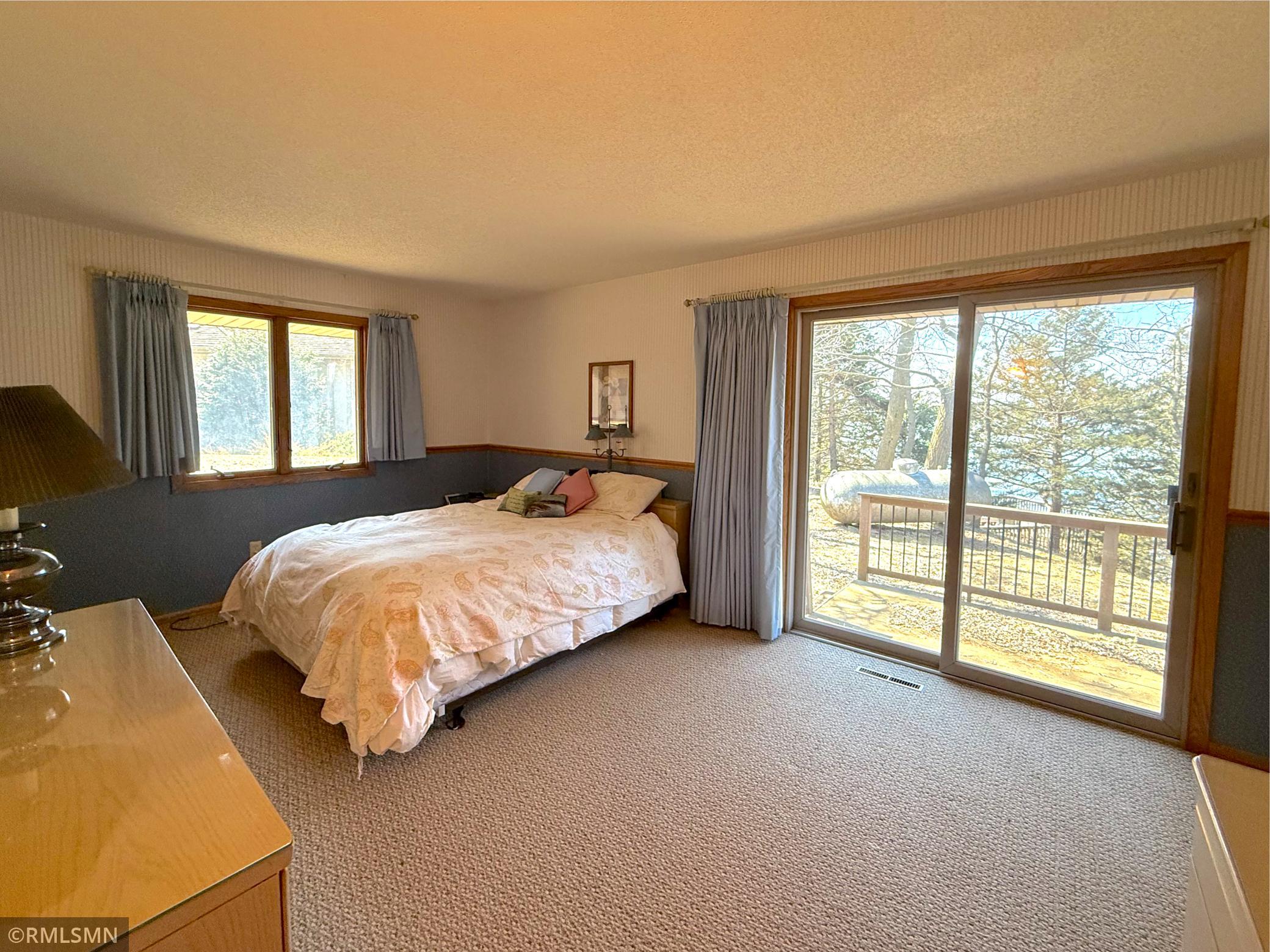 The primary bedroom offers a peaceful retreat with generous space and a sliding glass door leading calming views of Lake Sylvia.