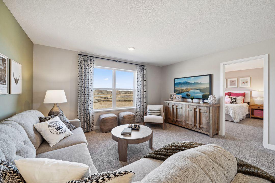 The upper-level loft provides an additional full size living space! Photo of a model home, color & options will vary.