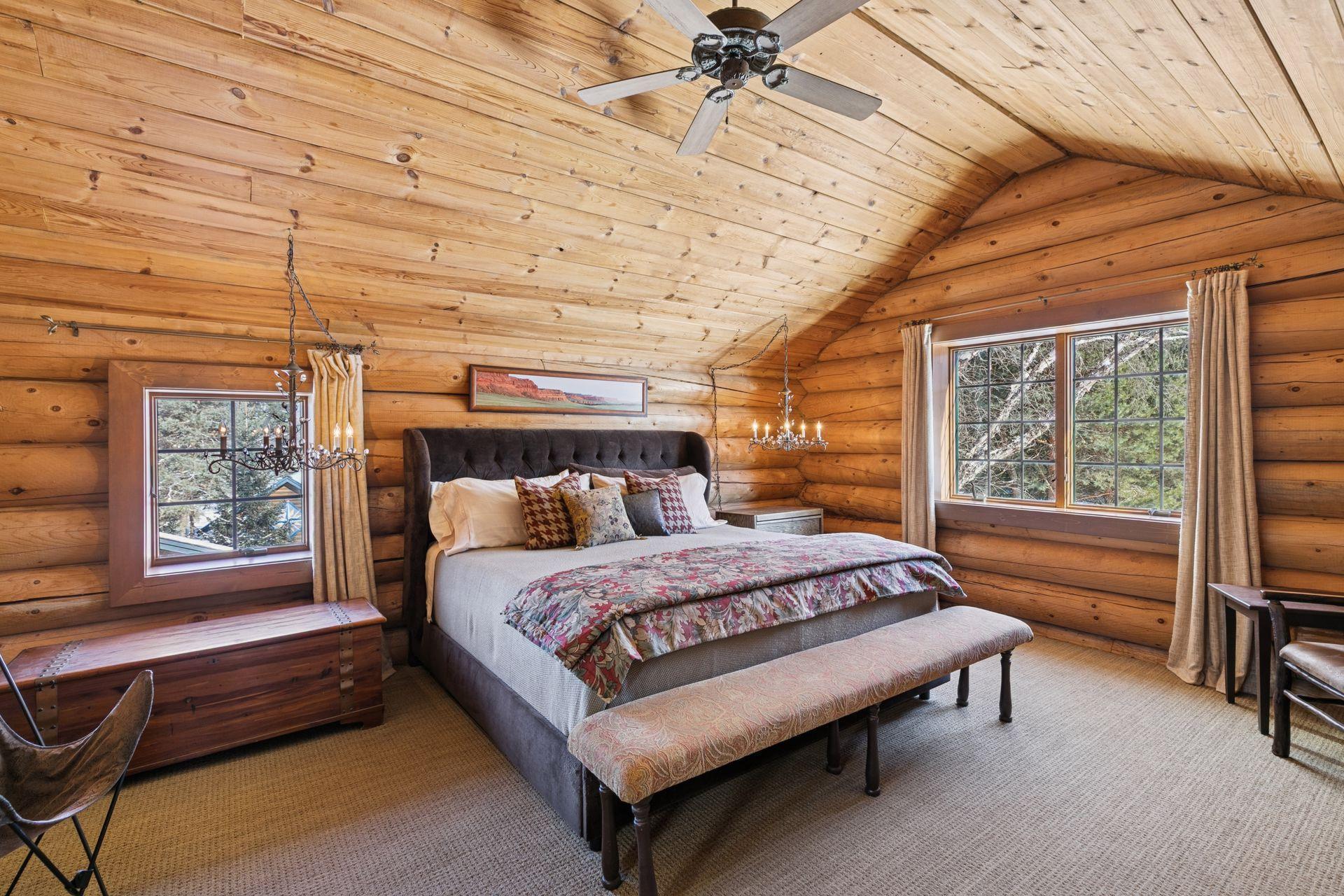 The primary bedroom continues the home’s rustic charm, featuring design elements that blend warmth, natural textures, and a cozy, inviting atmosphere.