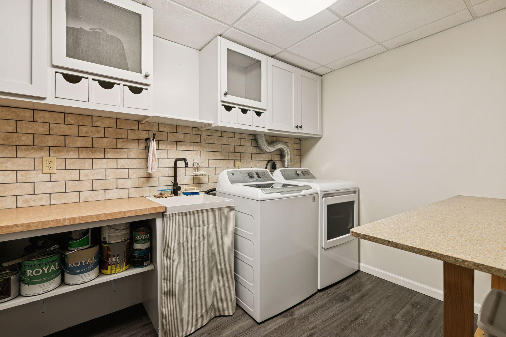 The finished lower level includes a dedicated laundry and craft room, offering functional space for household tasks and creative projects.