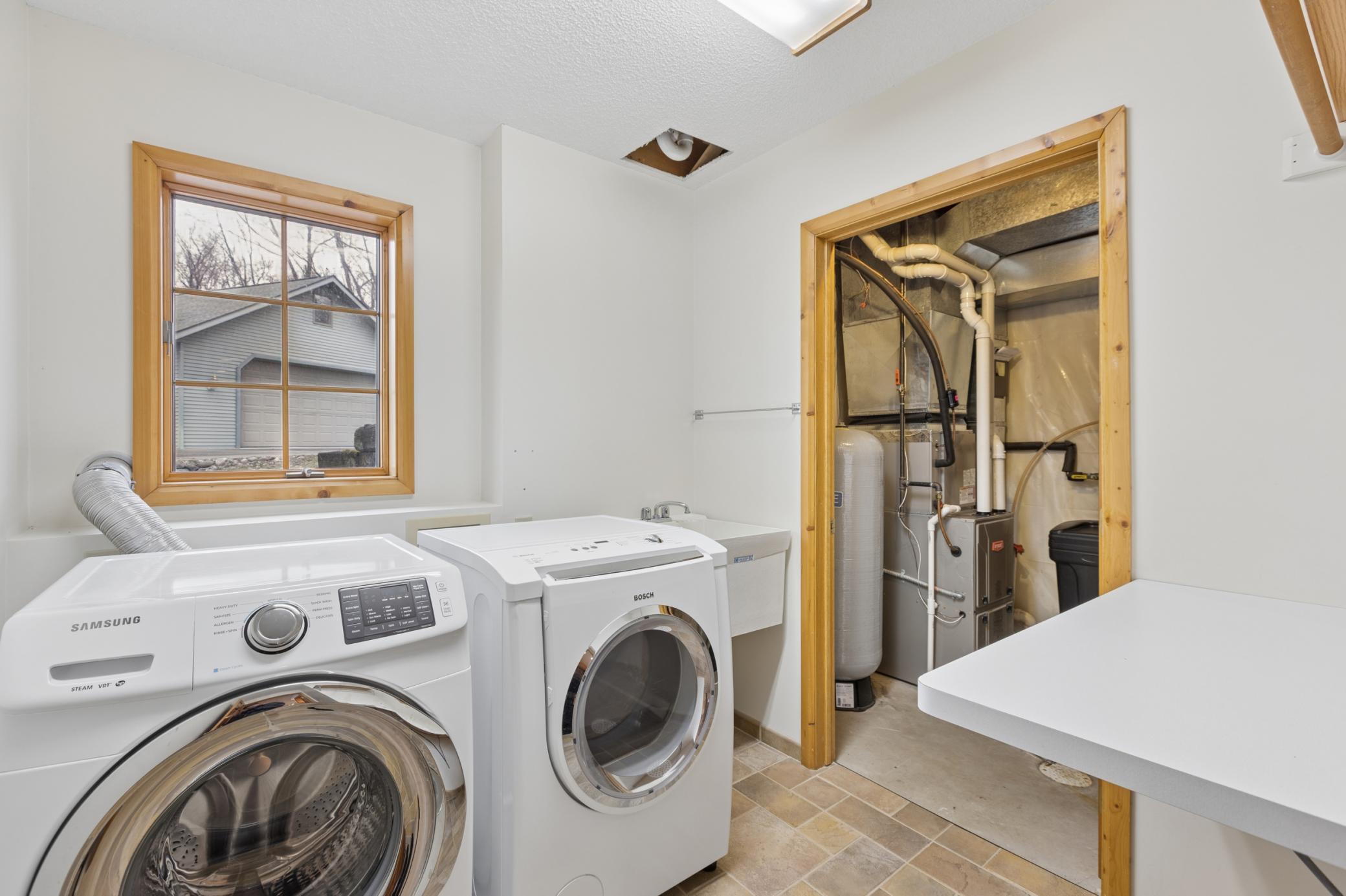 Just off the kitchen is the laundry room with a washtub sink. Through the door is the utility room housing the water heater, furnace, pressure tank and boiler for in-floor heat.