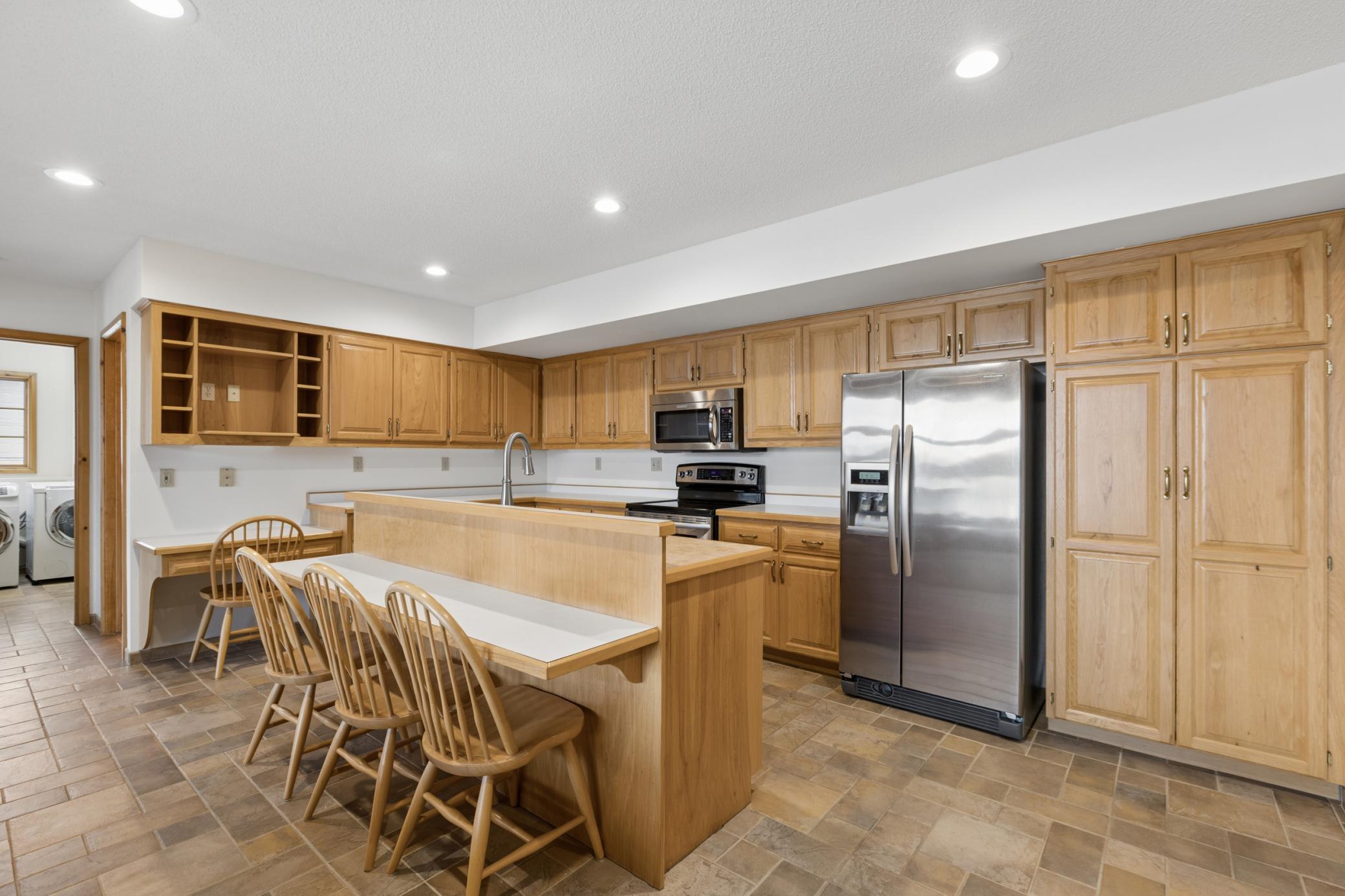 The kitchen offers plenty of storage along with a breakfast bar and you will love how the kitchen sink looks out over the living towards the windows overlooking Lake Marie.