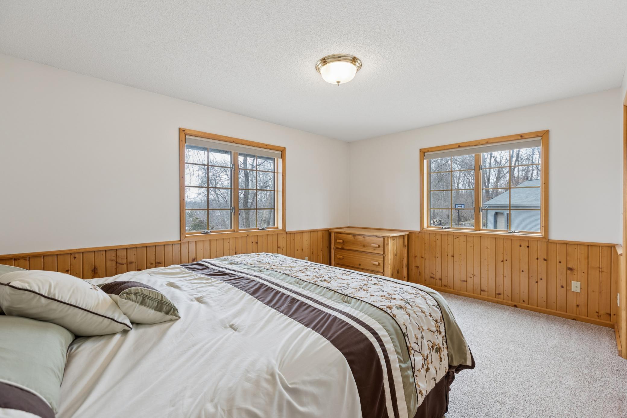 The master bedroom offers windows looking out towards the lake as well as overlooking the driveway/pole shed.